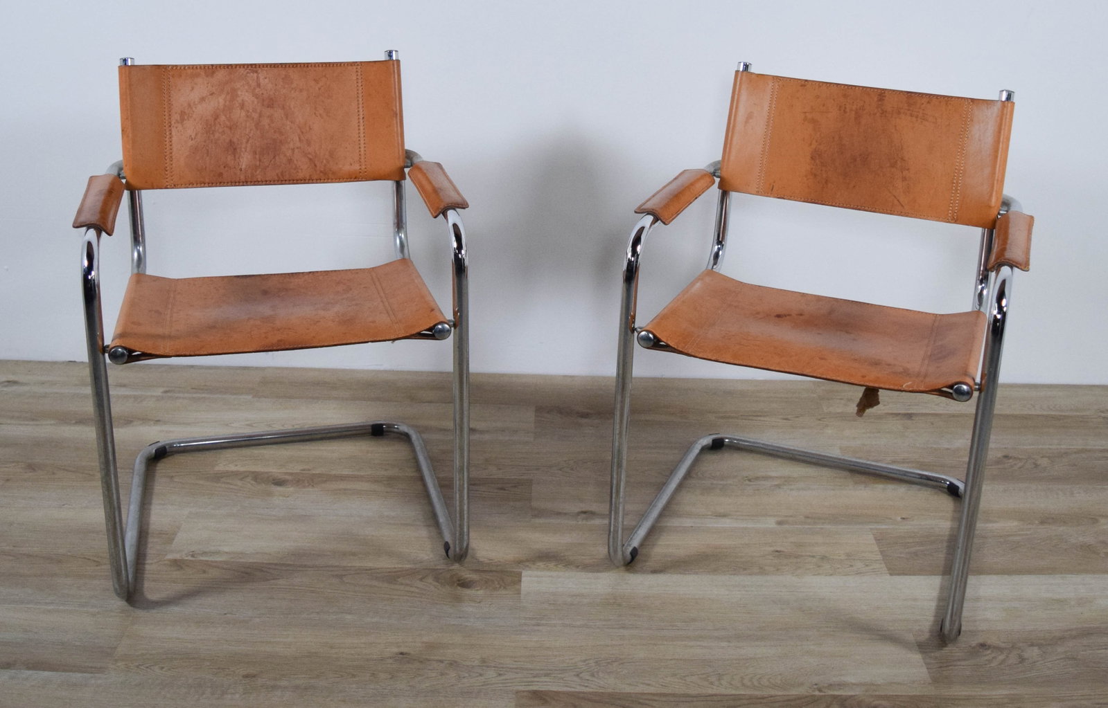 Pair of Mart Stam Style Cantilever Leather Chairs: Pair of Mart Stam style Bauhaus modern cantilever armchairs. Chrome, with leather seats and backs. Unsigned. Each 23 1/2"W x 23 3/8"D x 31 1/2"H, arm height 24 3/4", seat height 19". Both with stainin