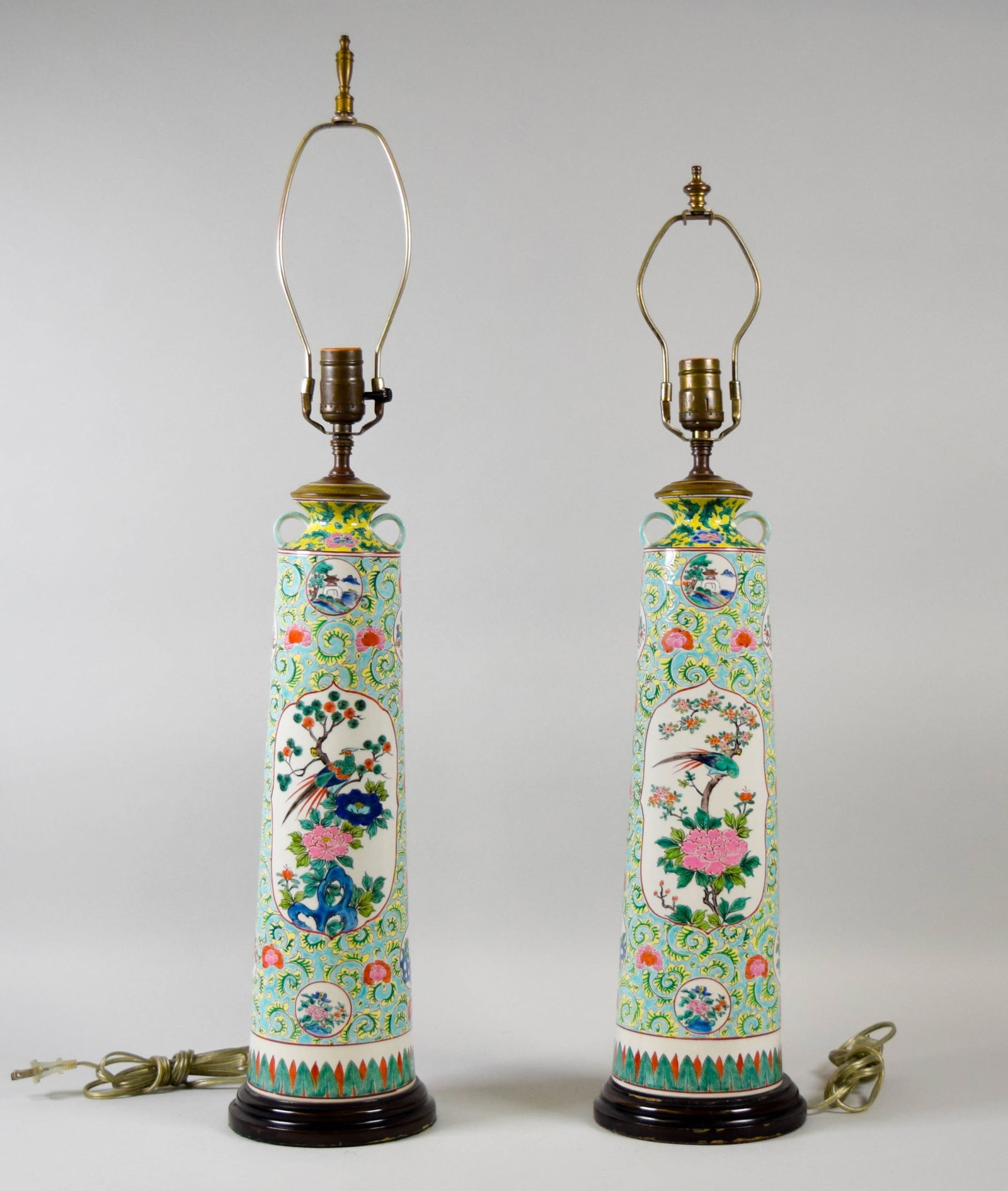 Pair Chinese Famille Rose Porcelain Lamps: Pair of Chinese famille rose porcelain lamps. On wooden bases. Each 23 1/4"H to top of socket. Both with chips and scratches to wooden bases; mismatched finials and harps.
