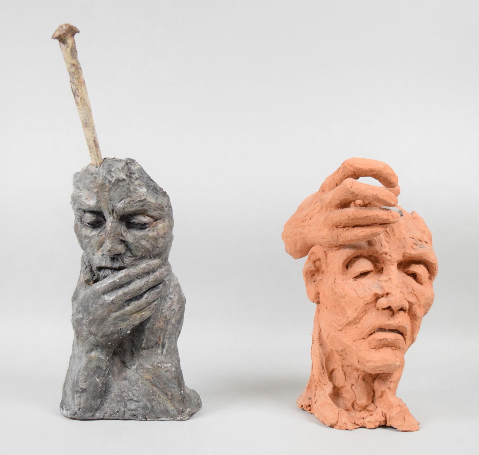 2 Clay Sculptures Initialed MG: 2 clay and railroad spike sculptures. Each artist initialed MG, dated 97 and titled in Italian Il Chiodo Fisso. 12"H and 16 3/4"H. Both with chips along the bases, larger with chips around hole for na