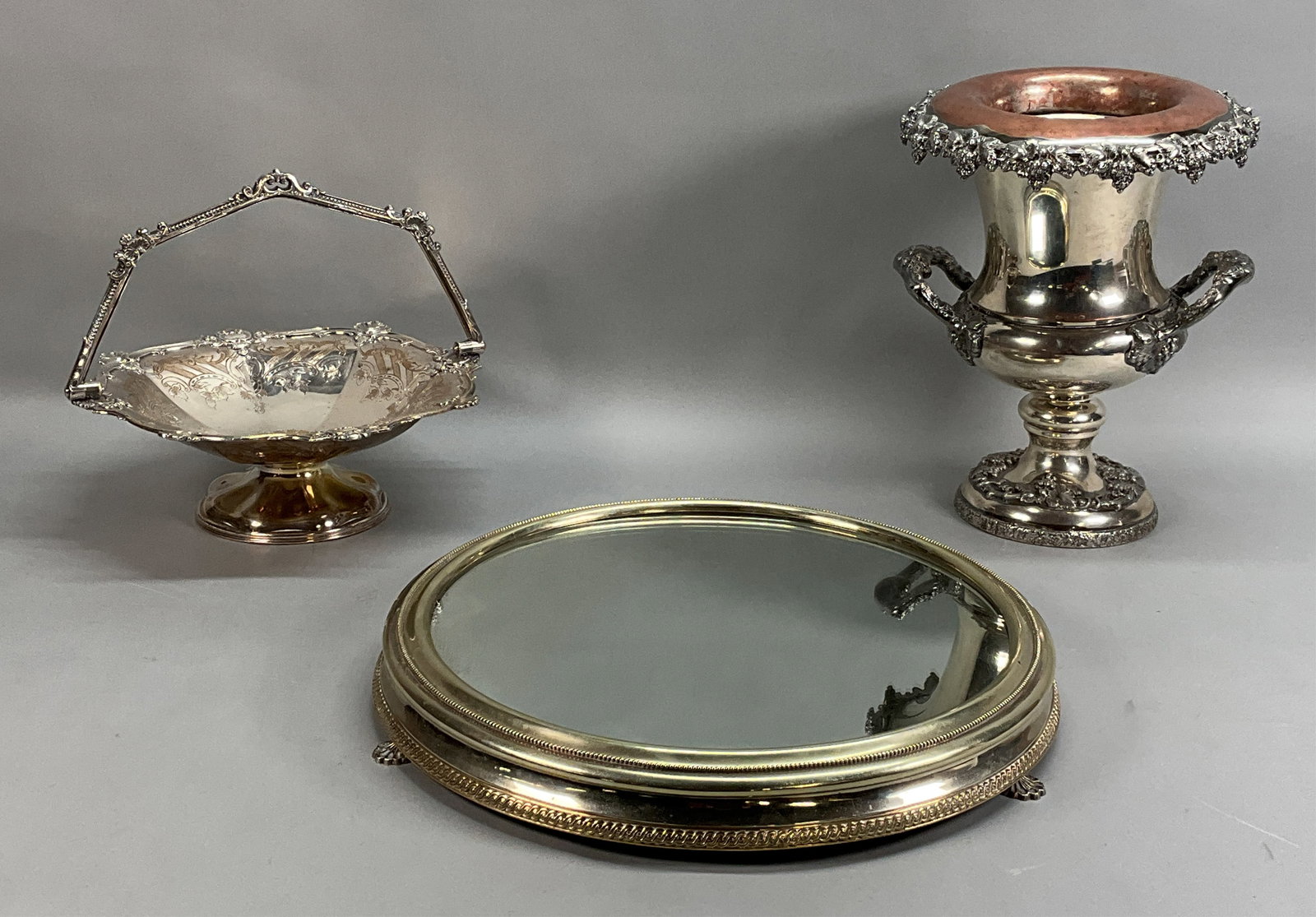 3 Pieces Silverplate Wine Cooler, Basket, Plateau: 3 pieces silverplate. Wine / champagne cooler, with grape and leaf motif, marked on the underside E.P. with a bird, 13 1/4"H; James Dixon & Sons, Sheffield basket, with chased floral motif, marked on