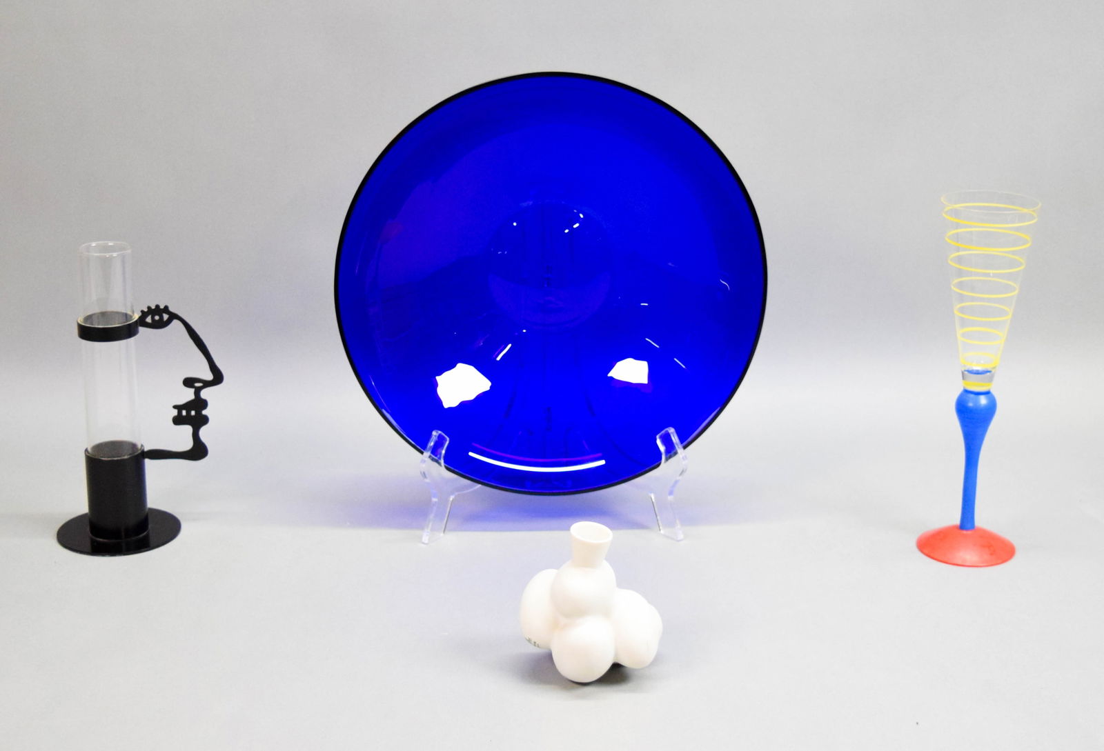 4 Modern Decorative Pieces Branzi, Anastasio: Lot of 4 modern decorative items. Andrea Anastasio cobalt blue art glass bowl, signed on the underside A. Anastasio Per Memphis Extra, 3 1/4"H x 12 3/4"-diameter; Anne Nilsson for Orrefors art glass "