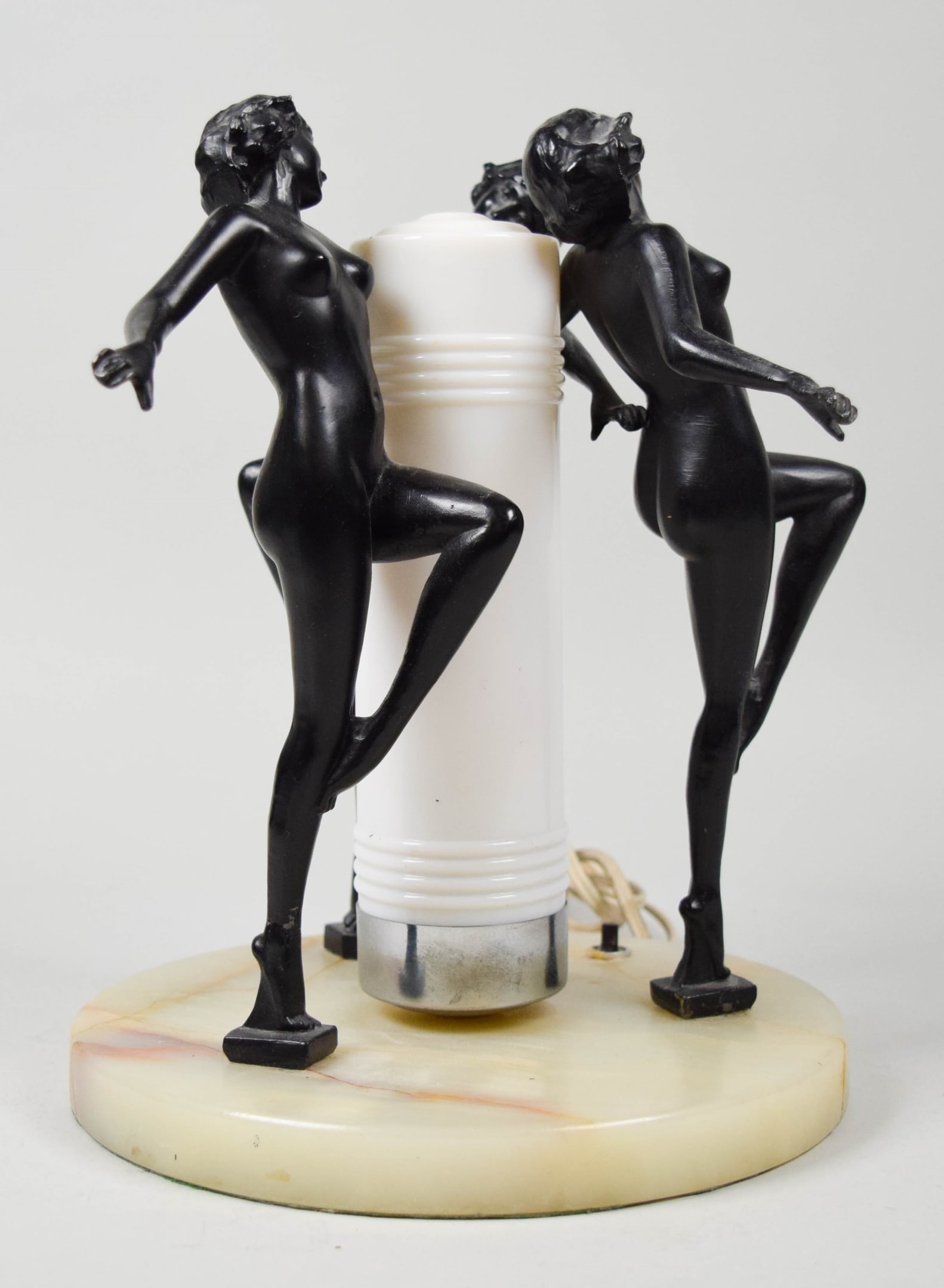 Art Deco Style Lamp 3 Dancers: Art deco style table lamp. 3 patinated metal figures of nude dancers, on an onyx base, with glass shade. Unsigned. 10 3/4"H x 8 1/2"-diameter at base. Base with cracks and repairs throughout, one figu