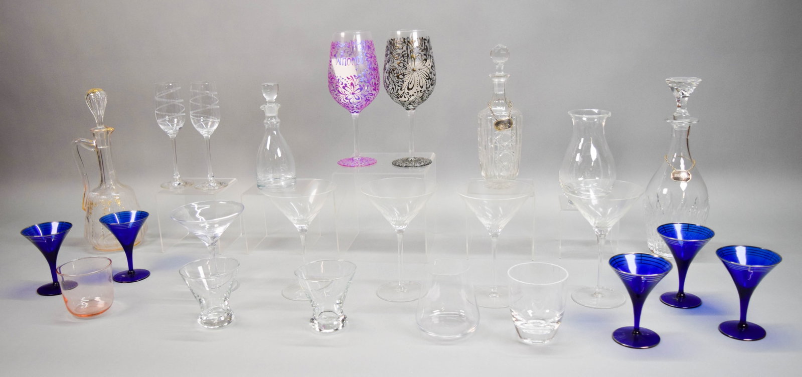 24 Pieces Barware Including Glassware, Decanters: 24 piece barware lot. Including, pair of Riedel champagne flutes, set of 4 martini glasses, Simon Pearce martini glass, 2 Grey Goose stemless martini glasses, Grey Goose plastic rocks glass, Gabriel s