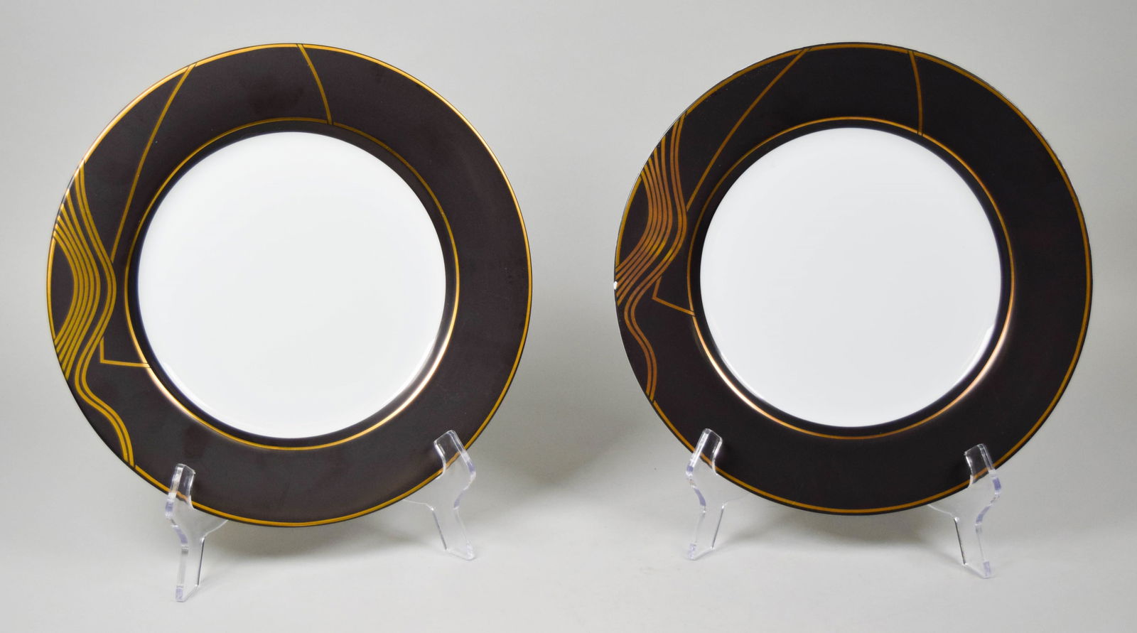 Pair of Arata Isozaki Swid Powell Stream Plates: Arata Isozaki for Swid Powell. Pair of "Stream" porcelain service plates. Each 12"-diameter. Both marked on the underside. Flake to the rim of one, chip to the underside of the rim on one, both with s