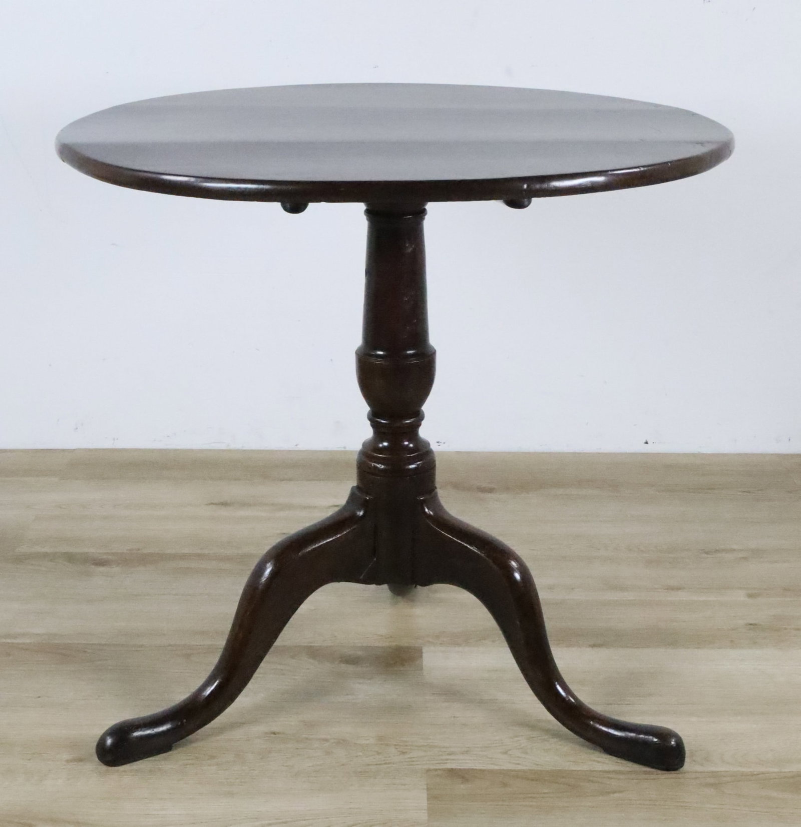 Tilt-Top Table: Tilt-top table. 27"H x 29"-diameter (43 1/4"H tilted up). Scratches and minor chips to legs, split to one leg, chips and scratches to table top.