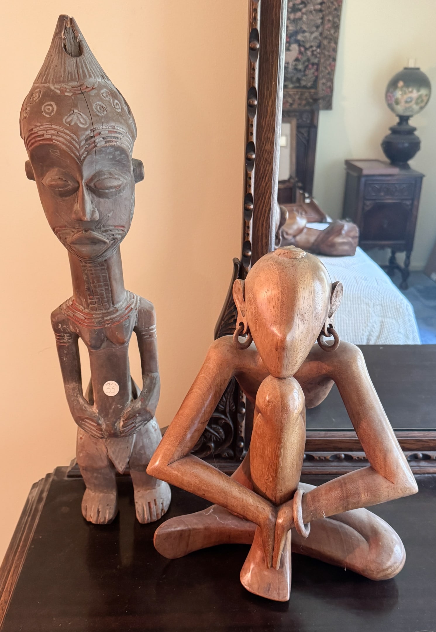 2 Carved African Wood Carvings: 2 Carved African Wood Carving, Largest 24" x 5" x 4" some damage to feet, Balinese wood carving 16" x 12" x 7" - both have scratches, scuffs and cracking in the wood from age.