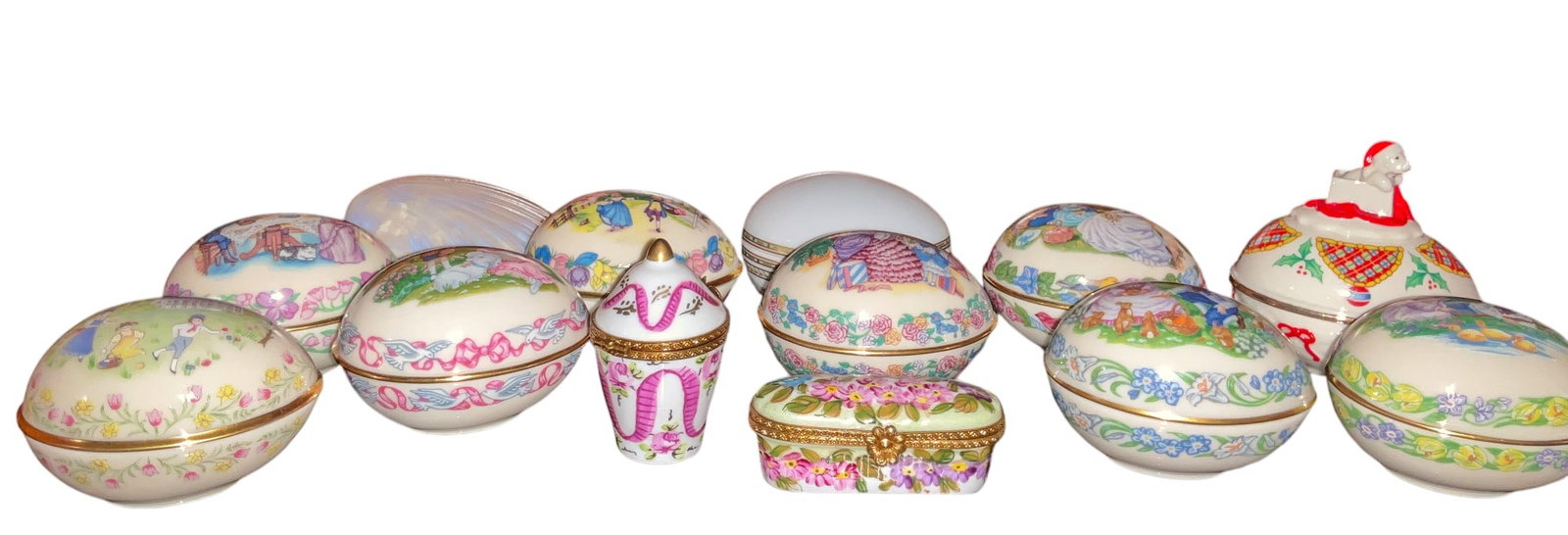13 Lenox & Limoges Decorative Egg Trinket Boxes: Thirteen Lenox and Limoges decorative trinket boxes. Includes eight 1990s Lenox Easter egg boxes, one Lenox Christmas Surprise collector egg, one Limoges mother of pearl seashell-shaped box, and two h