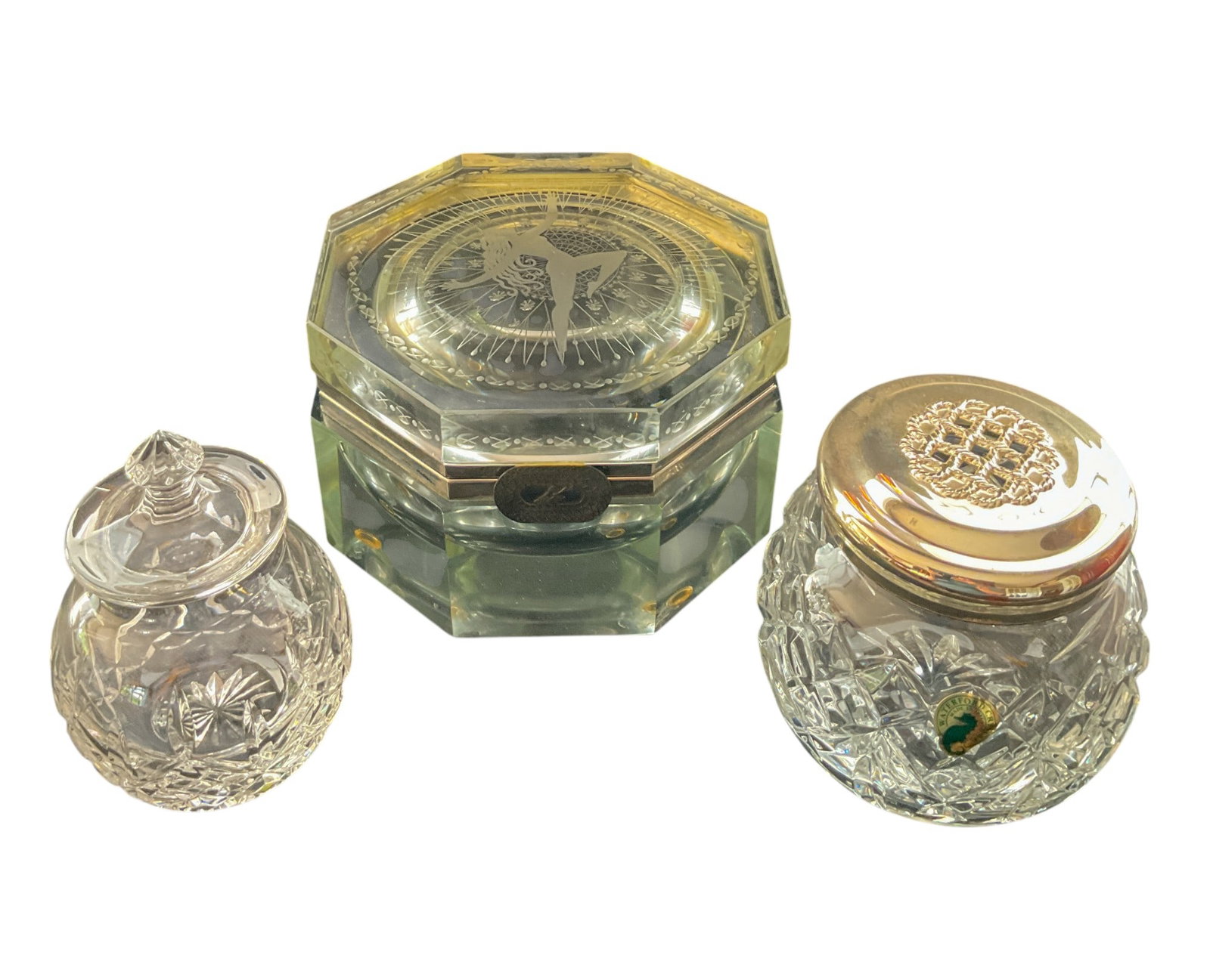 Erte Glass Lidded Box and Waterford Crystal Jars: Erte octagonal glass lidded box etched with an art nouveau-style female dancer. Features a silver rim and sterling Erte tag. Signed on bottom "Seven Arts 1989." Residue and cloudiness throughout. Two