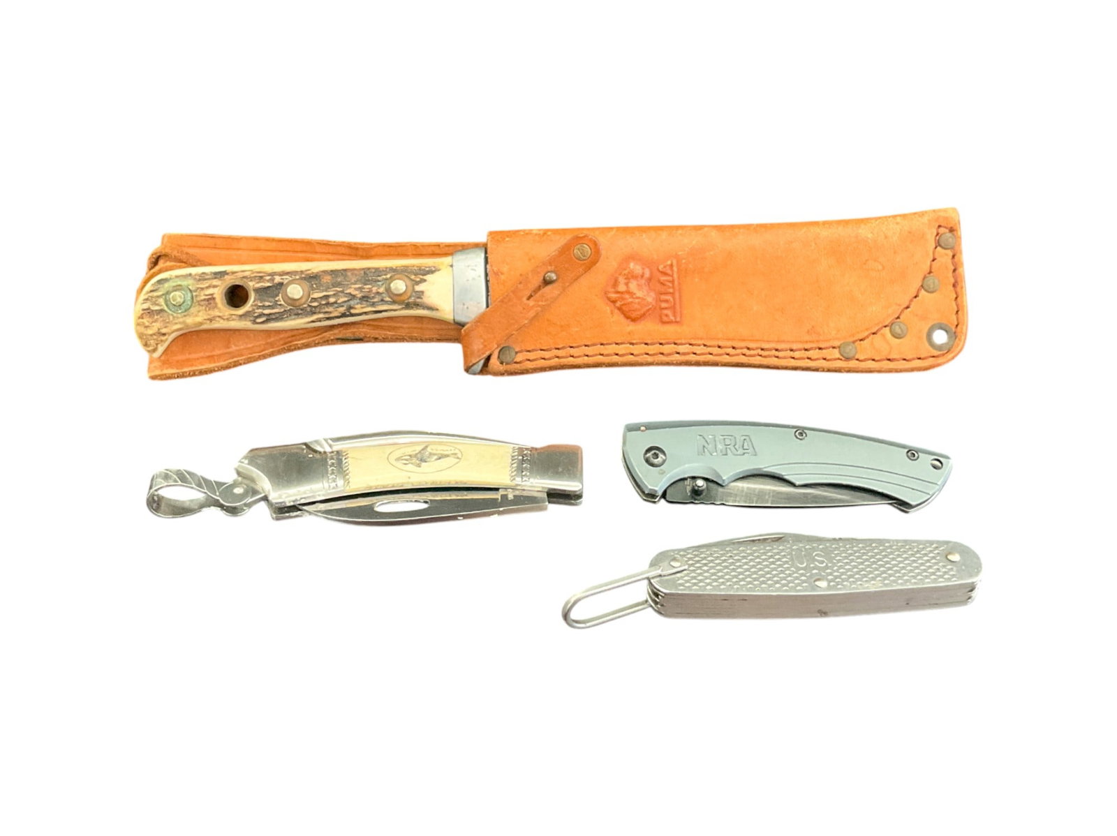 4 Vintage Knives Puma, Sam McDowell, US Military: Four vintage knives including one German Puma hunter knife, one Sam McDowell whale scrimshaw knife, one US military Camillus pocket knife, and one NRA pocket knife. Wear throughout all. Largest (Puma)