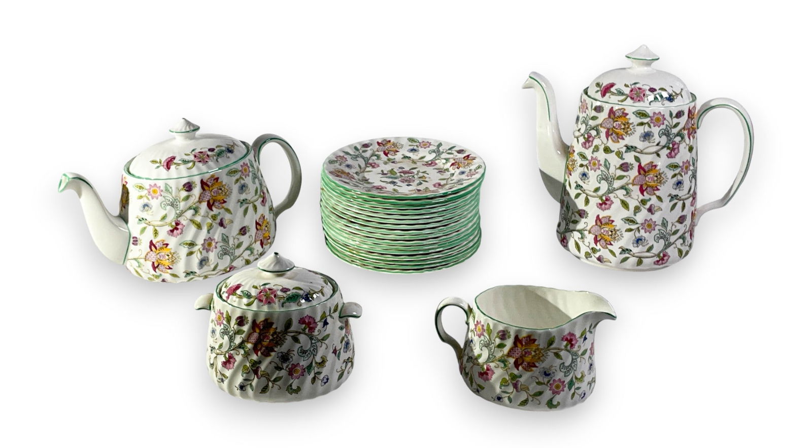 20 Pcs Minton Haddon Hall Tea Set & Saucers: Twenty pieces of Minton Haddon Hall porcelain green floral tea set components including two teapots, one sugar bowl, one creamer, and sixteen saucers. Marked Minton Bone China Made in England on under