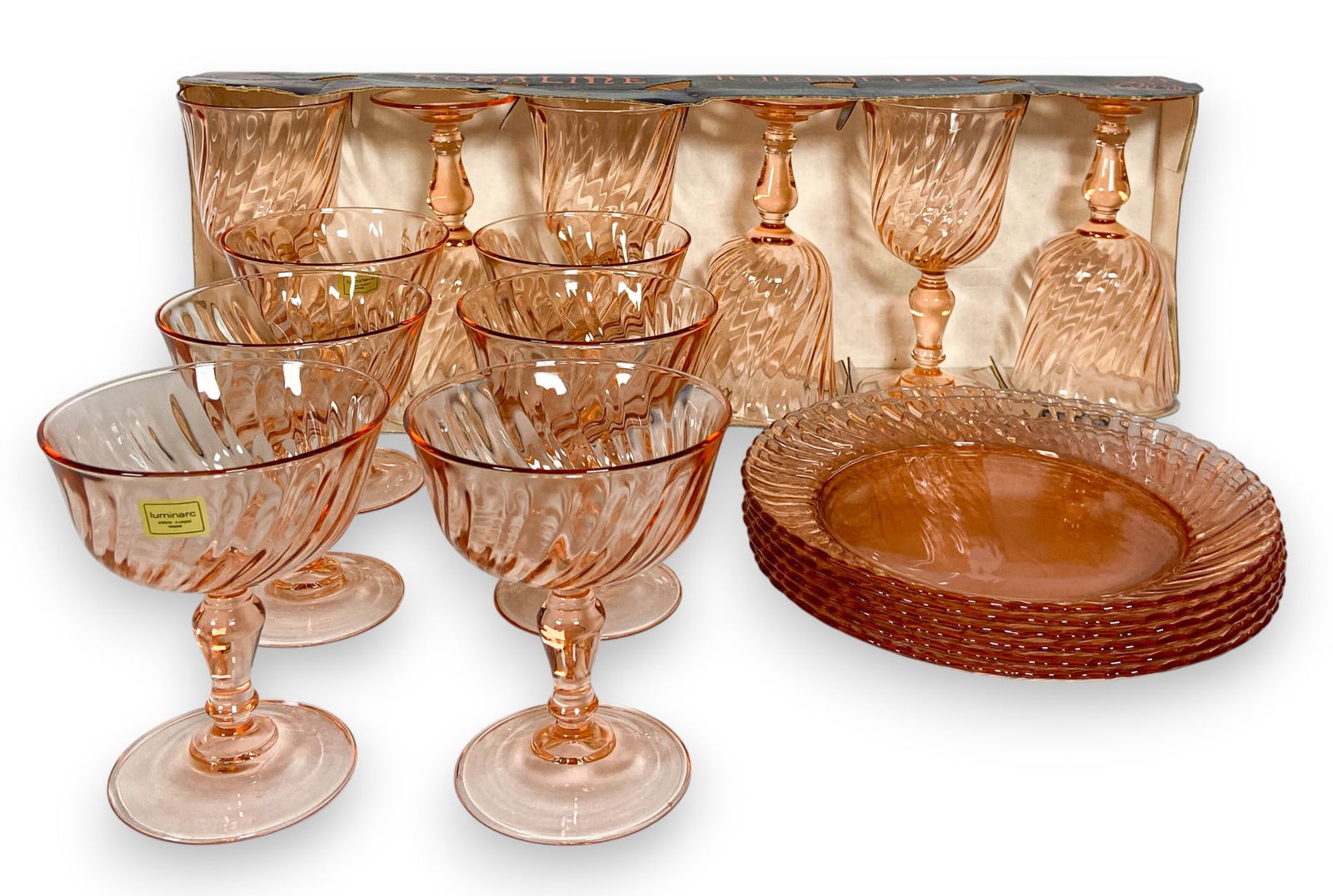 Luminarc France Pink Swirl Stemware & Plates: Eighteen pieces of French glass by Luminarc including six rosaline pink swirl wine glasses (6 1/2" H), six coupes or sherbert glasses (4 1/2" H), and six dessert plates (8" diameter). All marked Franc