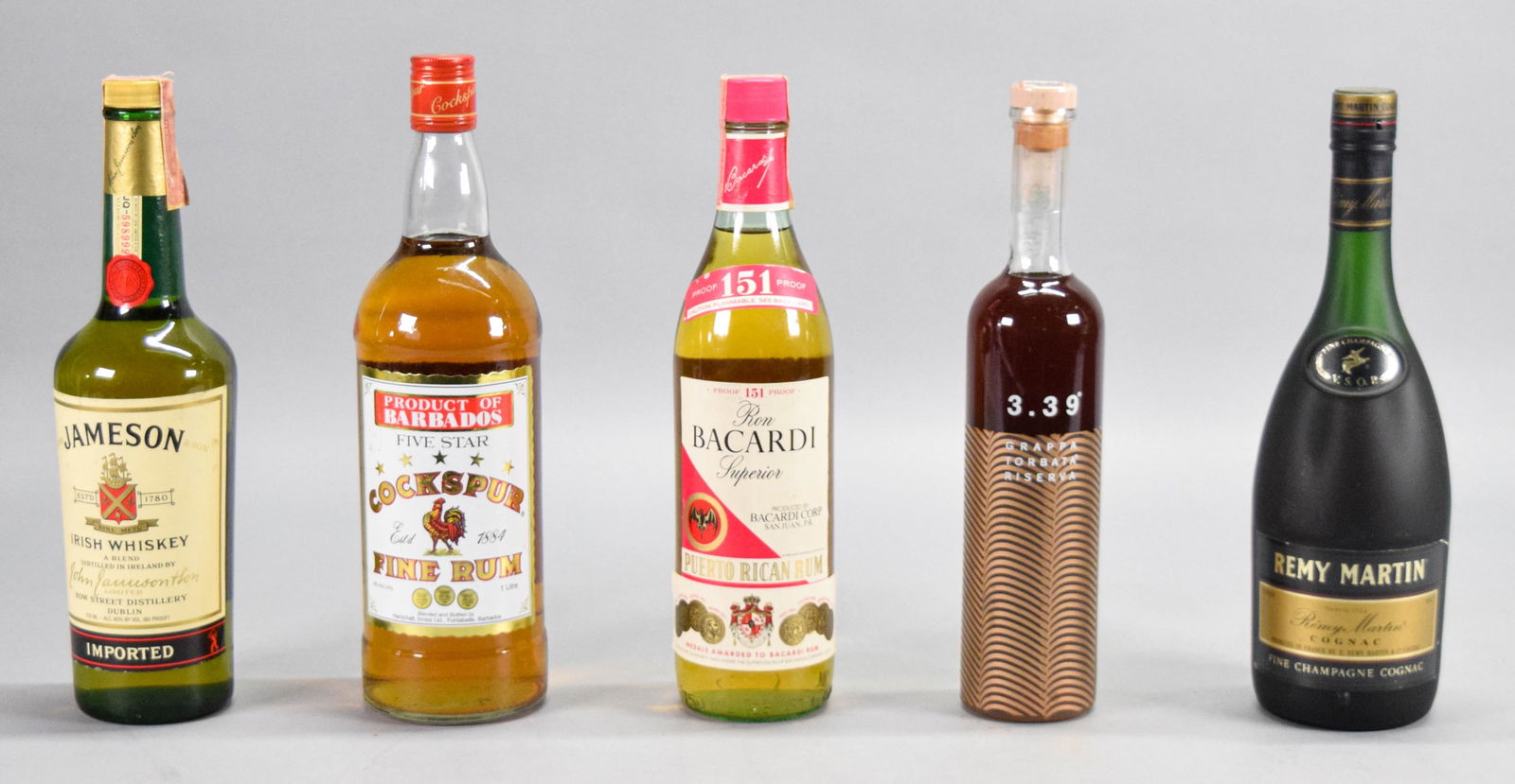 5 Bottles Of Vintage Liquor Jameson Remy Martin: 5 bottles of vintage liquor. 750 ML 1980s Jameson Irish Whiskey, tax stamp intact with a small amount of seepage. Bacardi Superior Rum. Vintage bottle of Remy Martin VSOP Cognac. 1 liter vintage Cocks