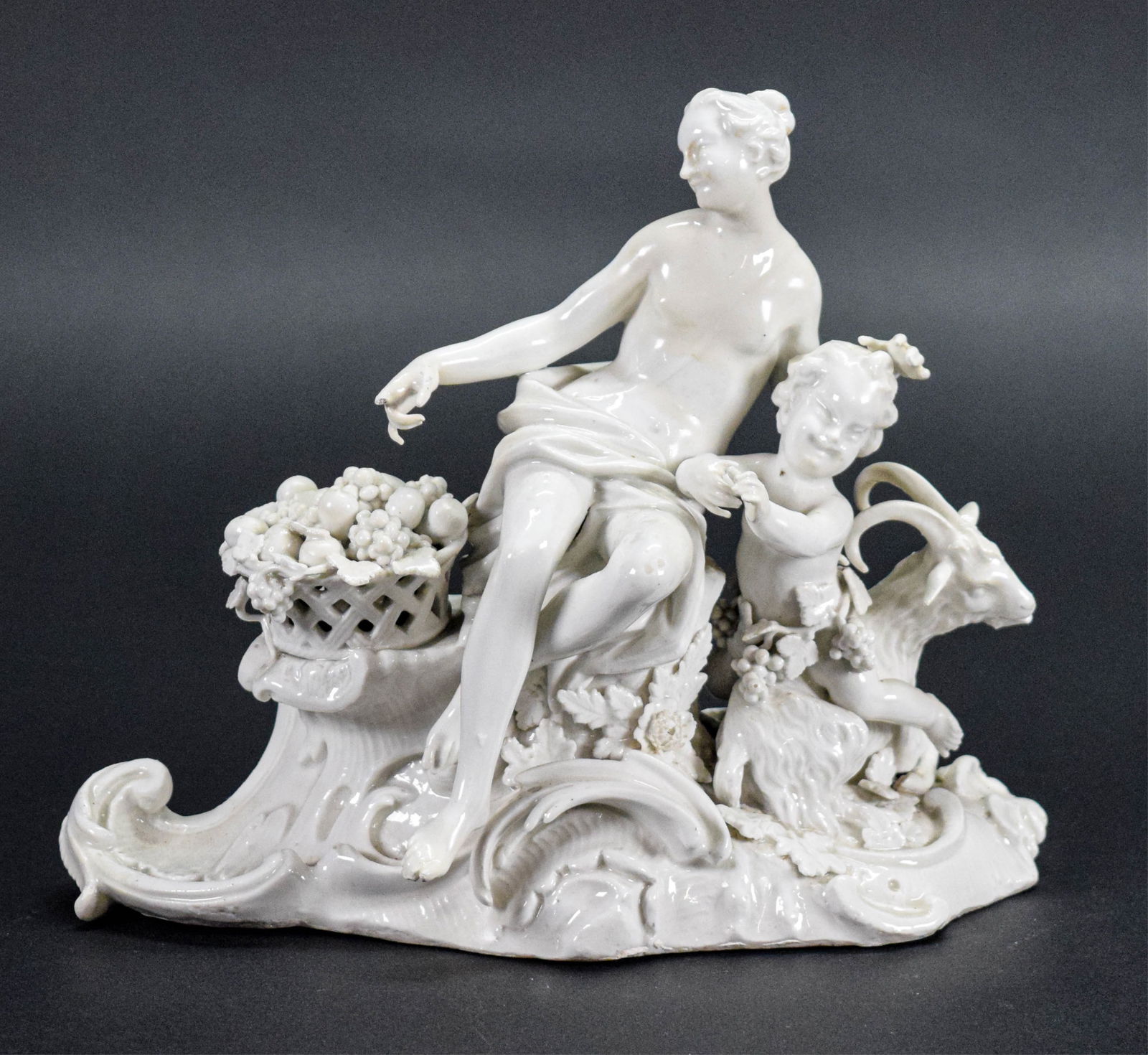 Meissen White Porcelain Figure Mother & Child: Meissen white German porcelain figure, mother and child with goat. Blue crossed swords mark on the underside. 6 5/8"H. Chips to leaves in fruit basket, chip to woman's finger, firing crack to the unde