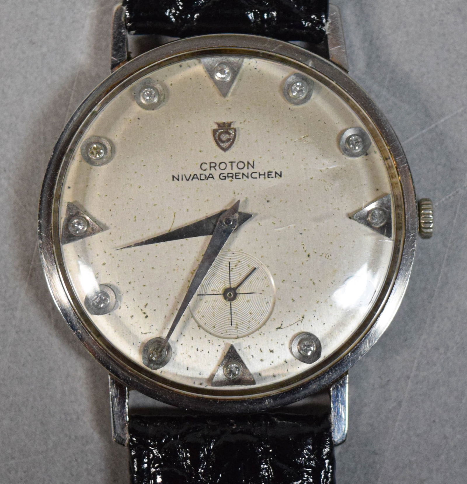 Croton Nivada Grenchen 18k Gold Wrist Watch: Croton Nivada Grenchen 18k white gold wristwatch. Leather band, marked 18k on the caseback. 32mm. Watch running, timekeeping untested. 27.4 grams total including crystal, movement and band. Discolorat