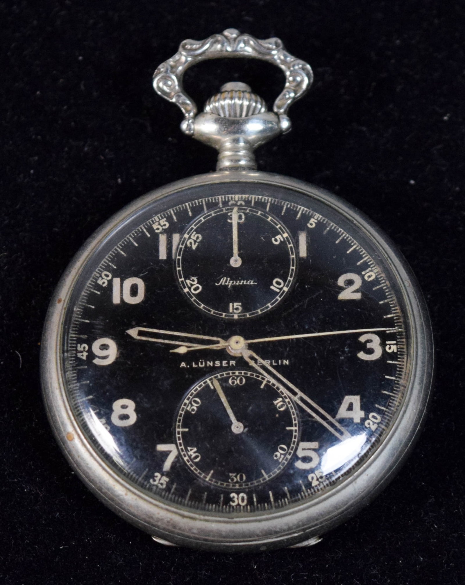 Lunser Alpina German Military Pocket Watch: Lunser German military pocket watch. Dial marked A. Lunser Berlin and Alpina. Watch and stopwatch running, timekeeping and other features untested. Movement 41.275mm, case 2"-diameter. Scratches to ca