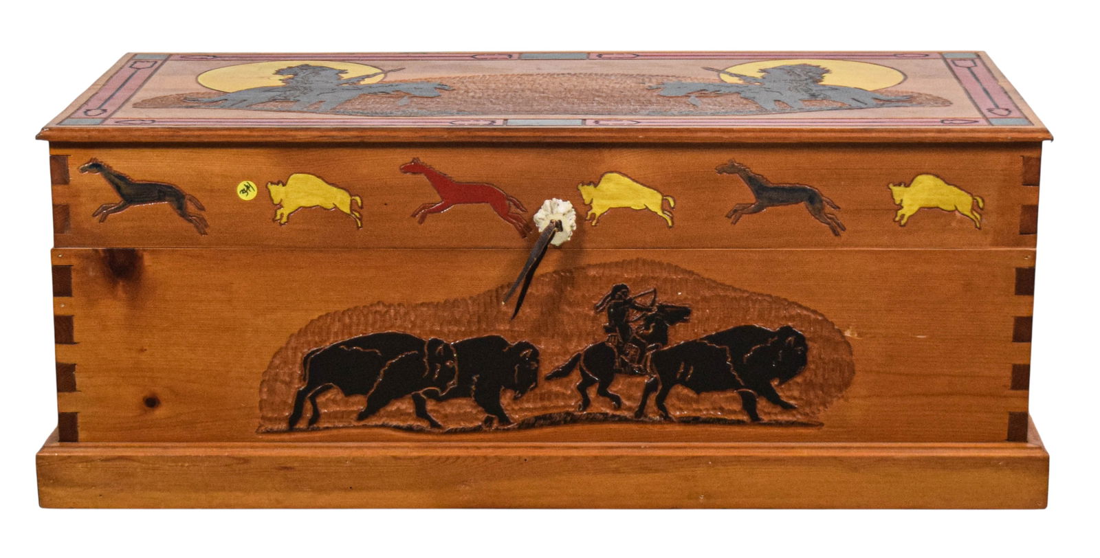 Pine Blanket Chest with Native American Motif: Pine blanket chest decorated with hand-carved Native American motifs. Dovetail joinery and antler latch on front. 15 1/2" H x 38 1/2" W x 17 1/2" D. Finish losses to lid, small chip to one edge, and s