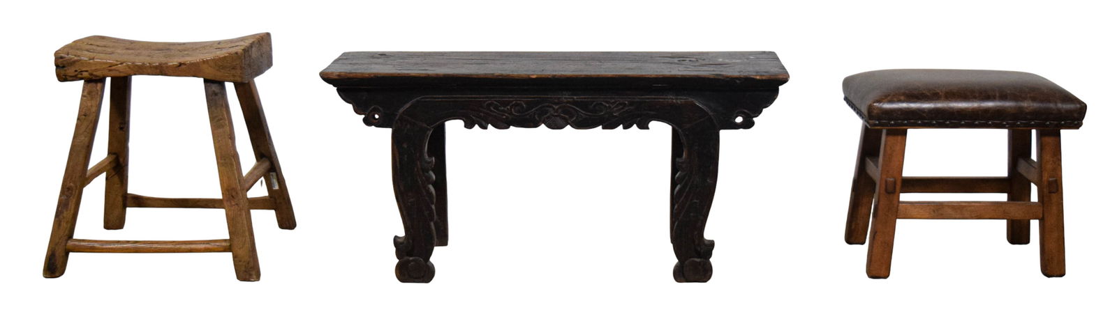 Group of Wood Stools: Group of 3 wooden stools featuring primitive and carved details. One low altar-style bench with a dark finish and carved scrollwork. One primitive style stool and one small rectangular stool with a di
