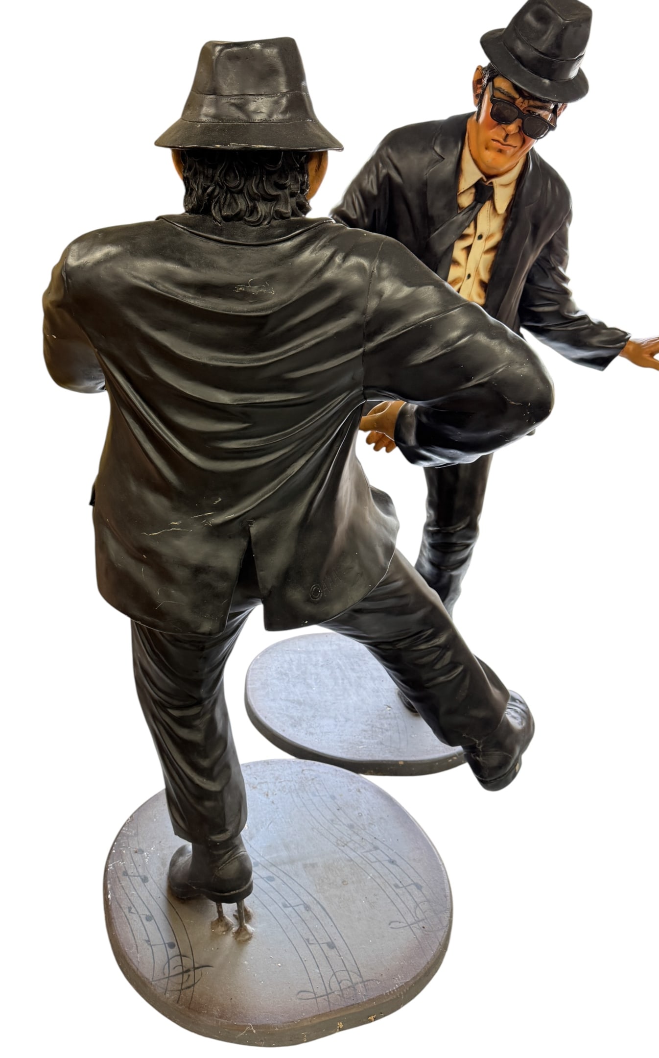 The Blues Brothers Jake and Elwood Statues: A pair of life-size painted composite or resin statues depicting characters inspired by The Blues Brothers. Each figure is dressed in a signature black suit, white shirt, black tie, fedora, and