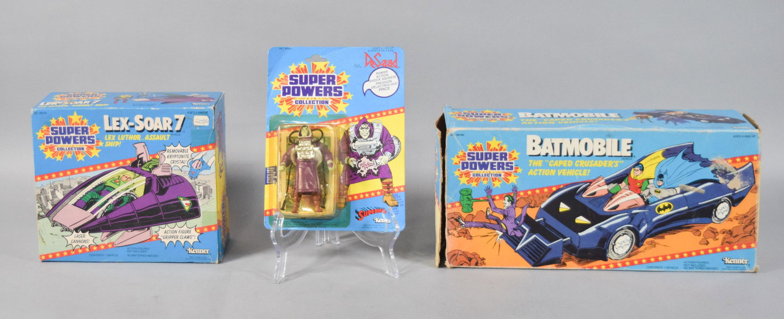 3 Kenner Super Powers Action Figure and Vehicles c. 1980s: Group of three original items from the Kenner Super Powers Collection including one action figure and two action vehicles. The first item is a factory-sealed Kenner Canada DeSaad action figure on a bi