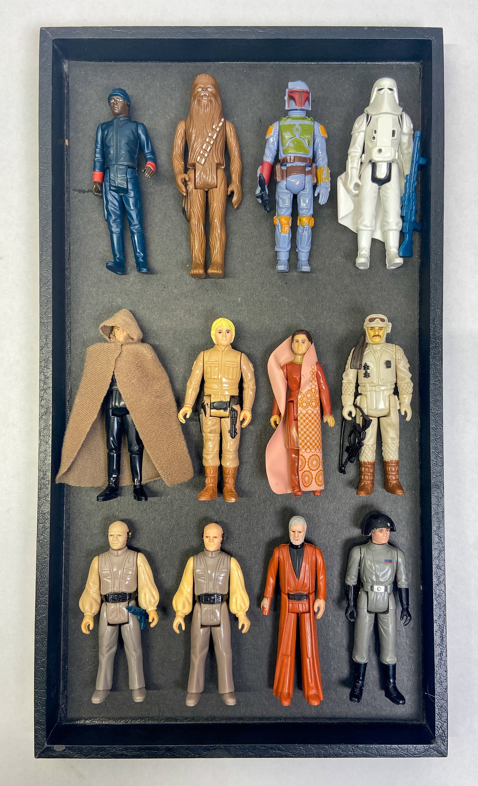 12 Vintage Kenner Star Wars Action Figures c. 1977-1983: Collection of 12 vintage Star Wars action figures manufactured by Kenner during the original film trilogy era. Features a variety of characters from the original trilogy, including Boba Fett, Chewbacc