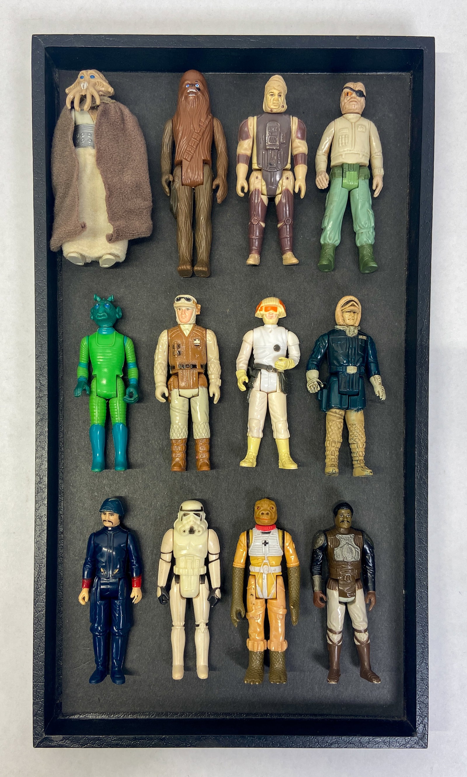 12 Vintage Kenner Star Wars Action Figures c. 1977-1984: Collection of 12 vintage Star Wars action figures manufactured by Kenner during the original film trilogy production era. Features iconic heroes, villains, and bounty hunters, including Chewbacca, a S