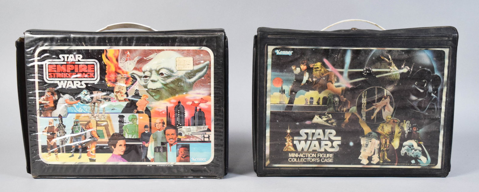 2 Kenner Star Wars Mini-Action Figure Carrying Cases: Two vintage Kenner Star Wars mini action figure vinyl carrying cases. Both cases feature black vinyl-wrapped exteriors with printed graphic panels and white plastic handles. The interiors contain plas