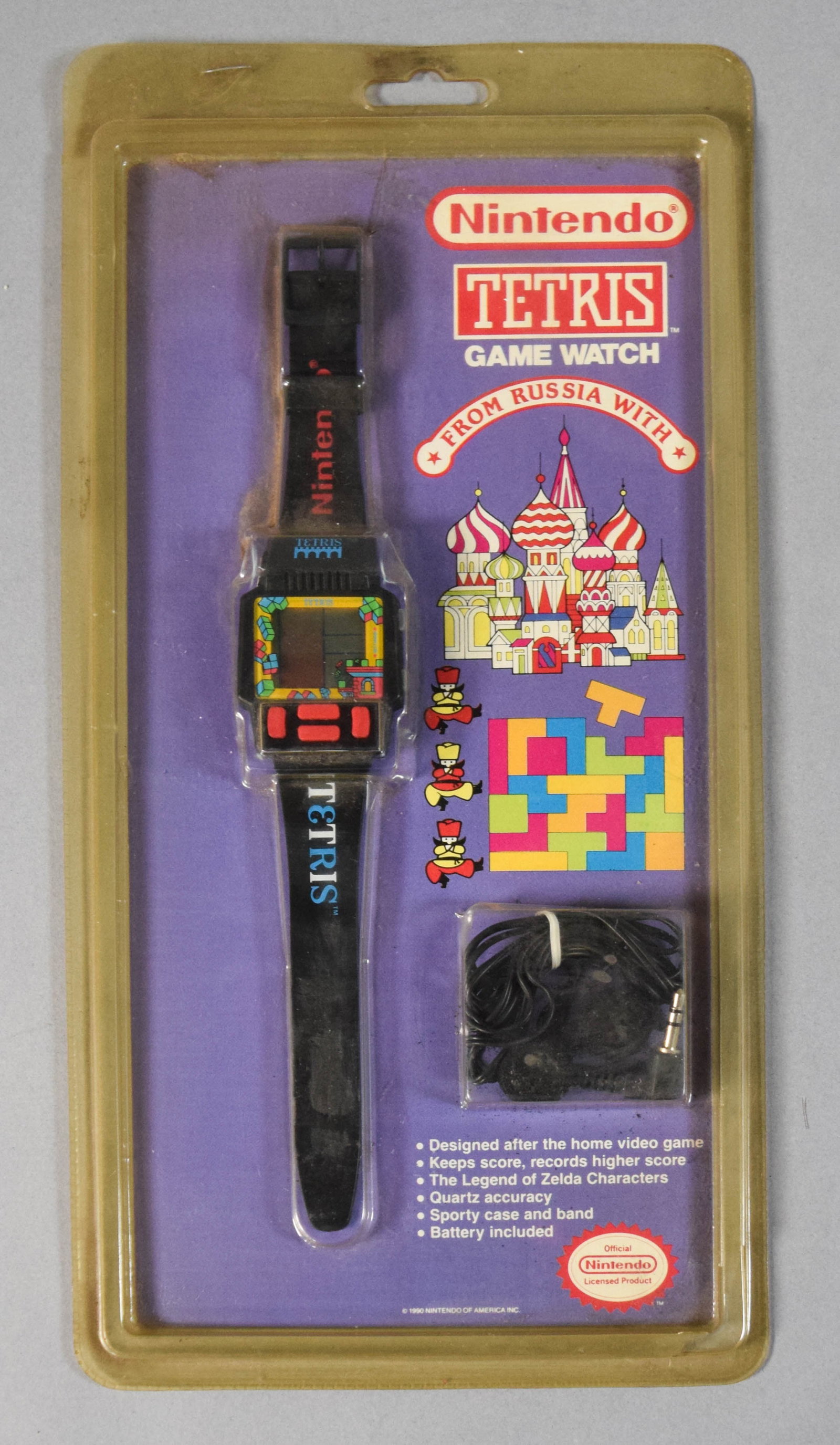 Vintage 1990 Nintendo Tetris Game Watch Factory Sealed on Original Blister Card: Factory-sealed Tetris Game Watch manufactured by Nintendo in 1990. Mounted on its original purple blister card with a notable printing error present in the feature list, which includes a bullet point
