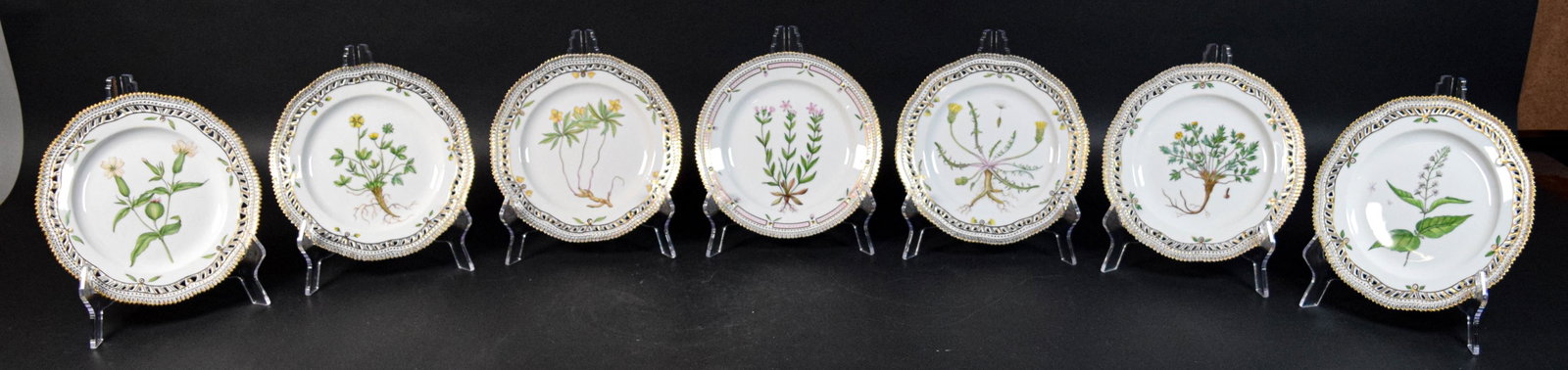 7 Royal Copenhagen Flora Danica Luncheon Plates: 7 Royal Copenhagen Flora Danica porcelain luncheon plates. With hand painted botanical motifs and gilt decoration, 4 with pierced rims. Royal Copenhagen marks on the undersides. 1 c. 1960, 2 c. 1980-8