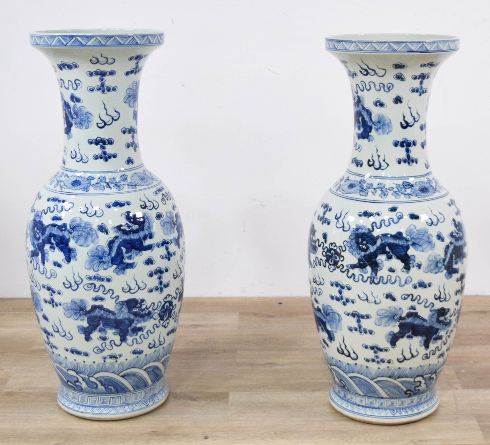 Pair of Chinese Blue and White Foo Lion Floor Vases: Large pair of Chinese blue and white porcelain floor vases. Baluster form vases with flared rims and cobalt blue decoration with Foo lions, clouds, and flame motifs. 37" H x 11 1/2" base diameter.