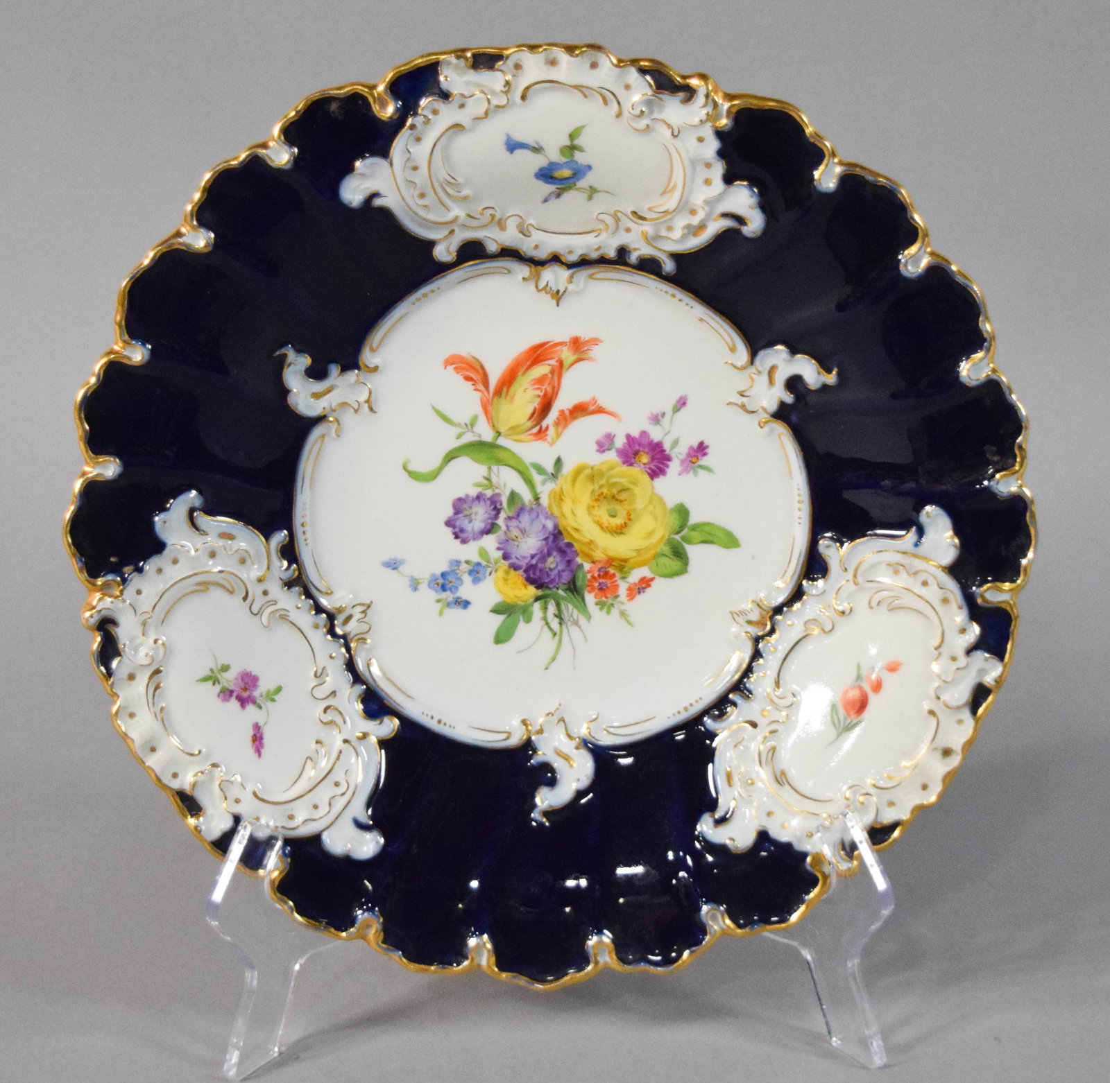 Meissen Cobalt Blue Porcelain Cabinet Plate: Meissen cobalt blue and gilt floral porcelain cabinet plate. Late 19th to early 20th century. Hand-painted floral reserve, cobalt blue rim, and gilded edge. Marked on the underside. 11 3/4" diameter.