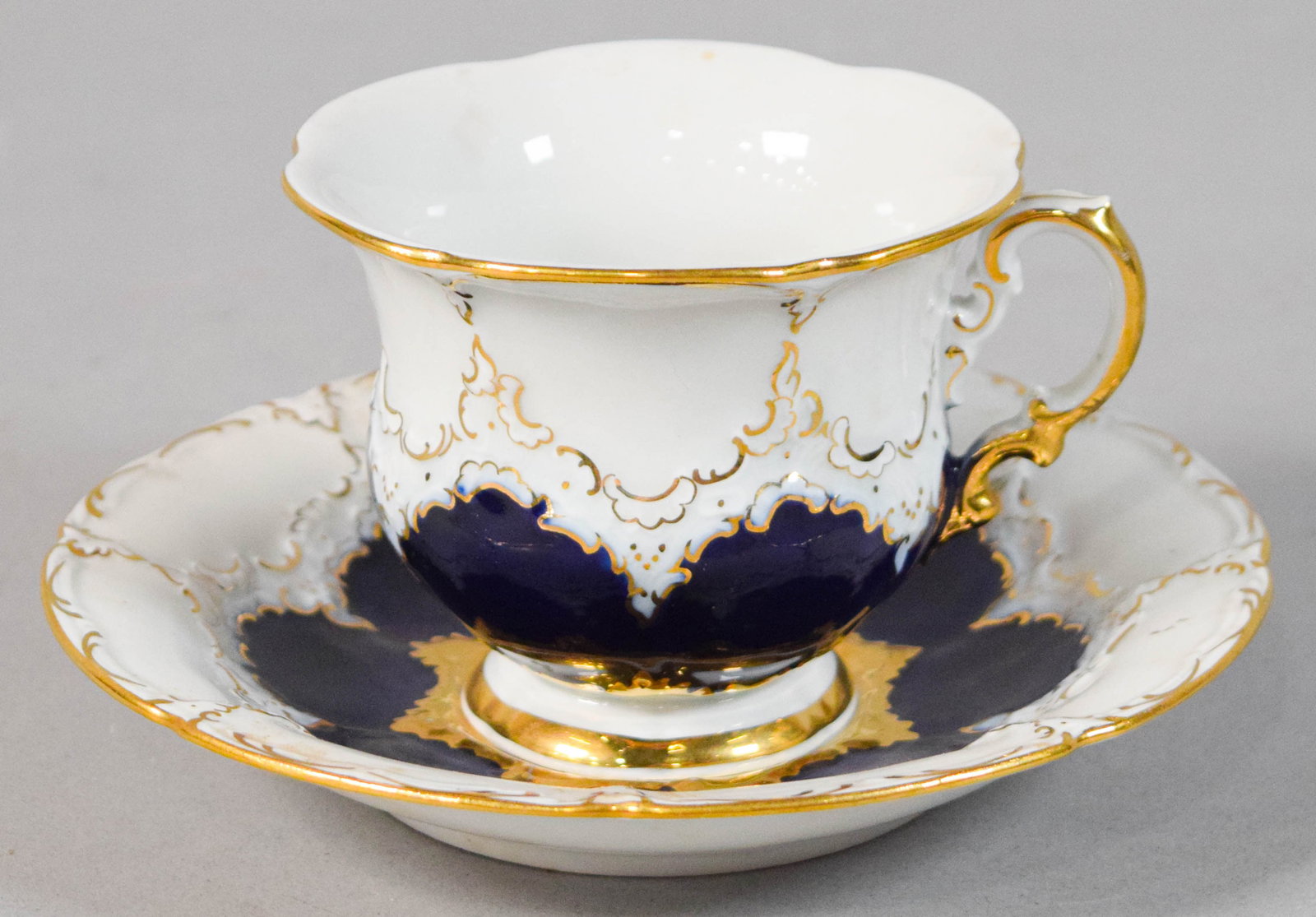 Meissen Cobalt Blue and Gilt Porcelain Teacup and Saucer: Meissen cobalt blue and gilt porcelain teacup and matching saucer. Marked on the underside of the teacup and saucer. Teacup 3 1/8" H, saucer 7 1/2" diameter.