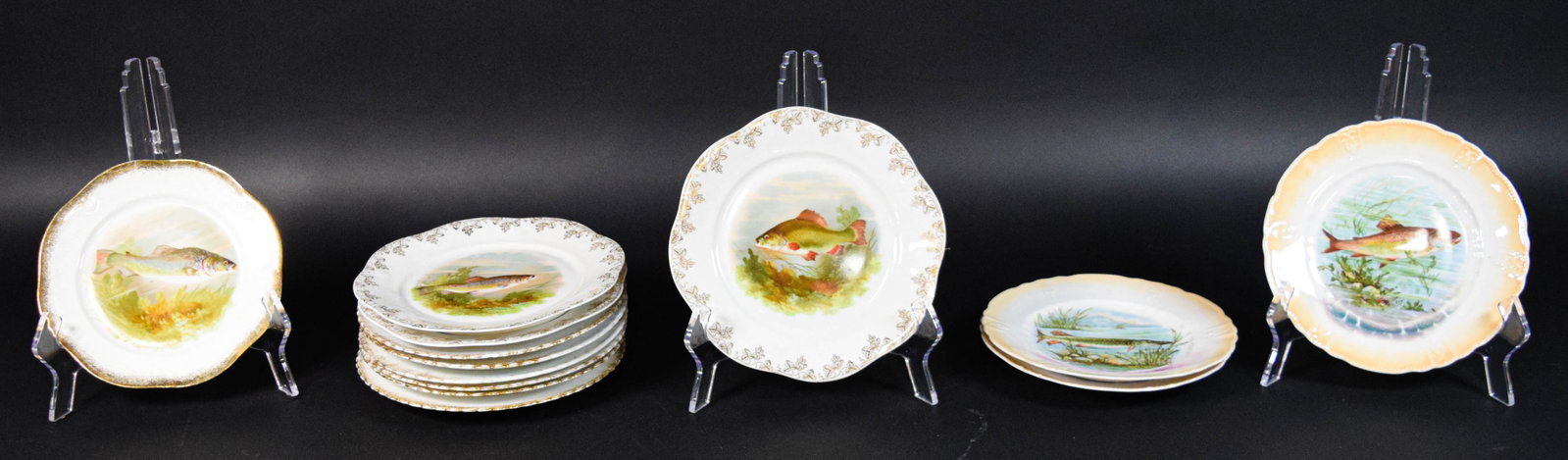 13 European Porcelain Fish Plates: Collection of 13 porcelain fish plates from various European makers. Marks include Eigner Z.S. and Co Bavaria, Victoria Carlsbad Austria, and Germany 164. Largest plate 9 1/2" diameter.