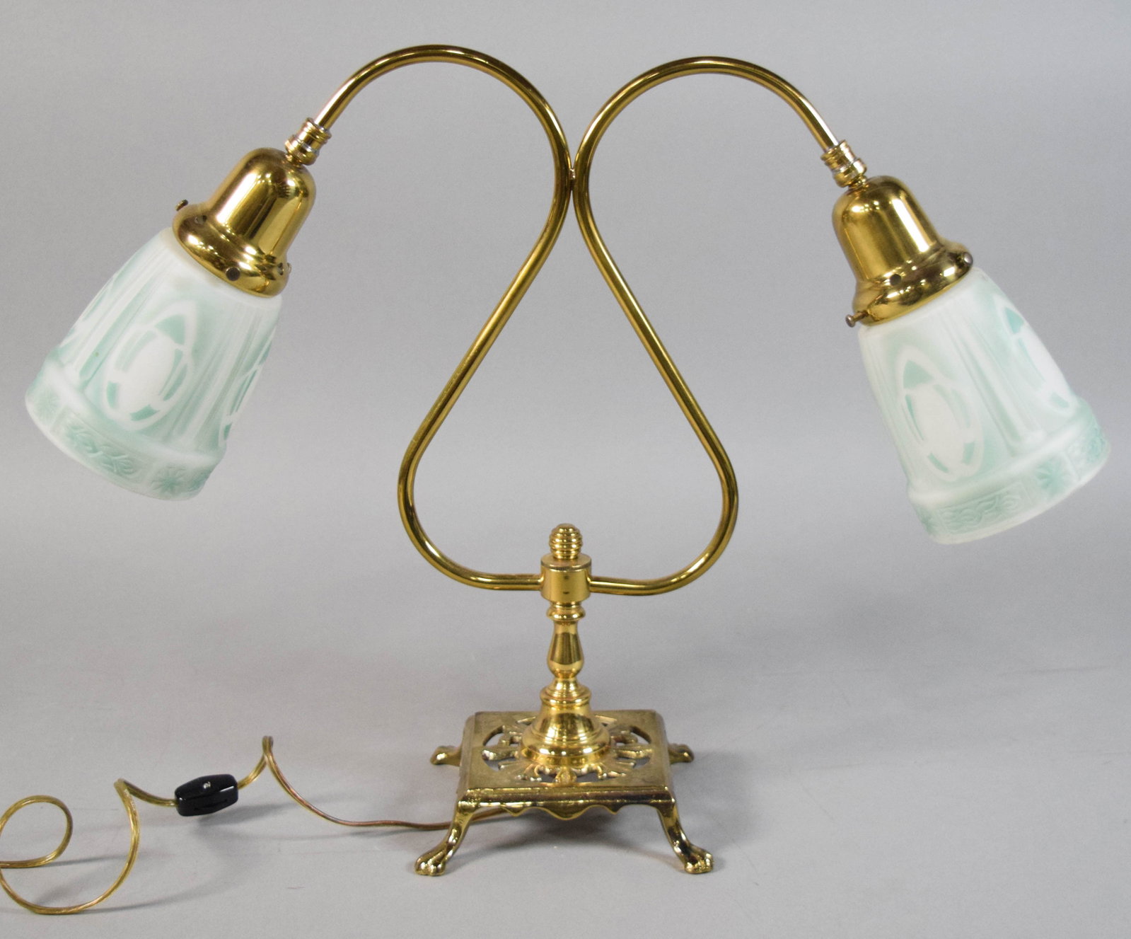Double Arm Student Lamp with Frosted Glass Shades: Double-arm electric student lamp with brass body and glass shades. Bell-shaped shades with frosted white glass decorated with green stenciled Art Deco style patterns. Tested and working. 15 1/4" H x 2