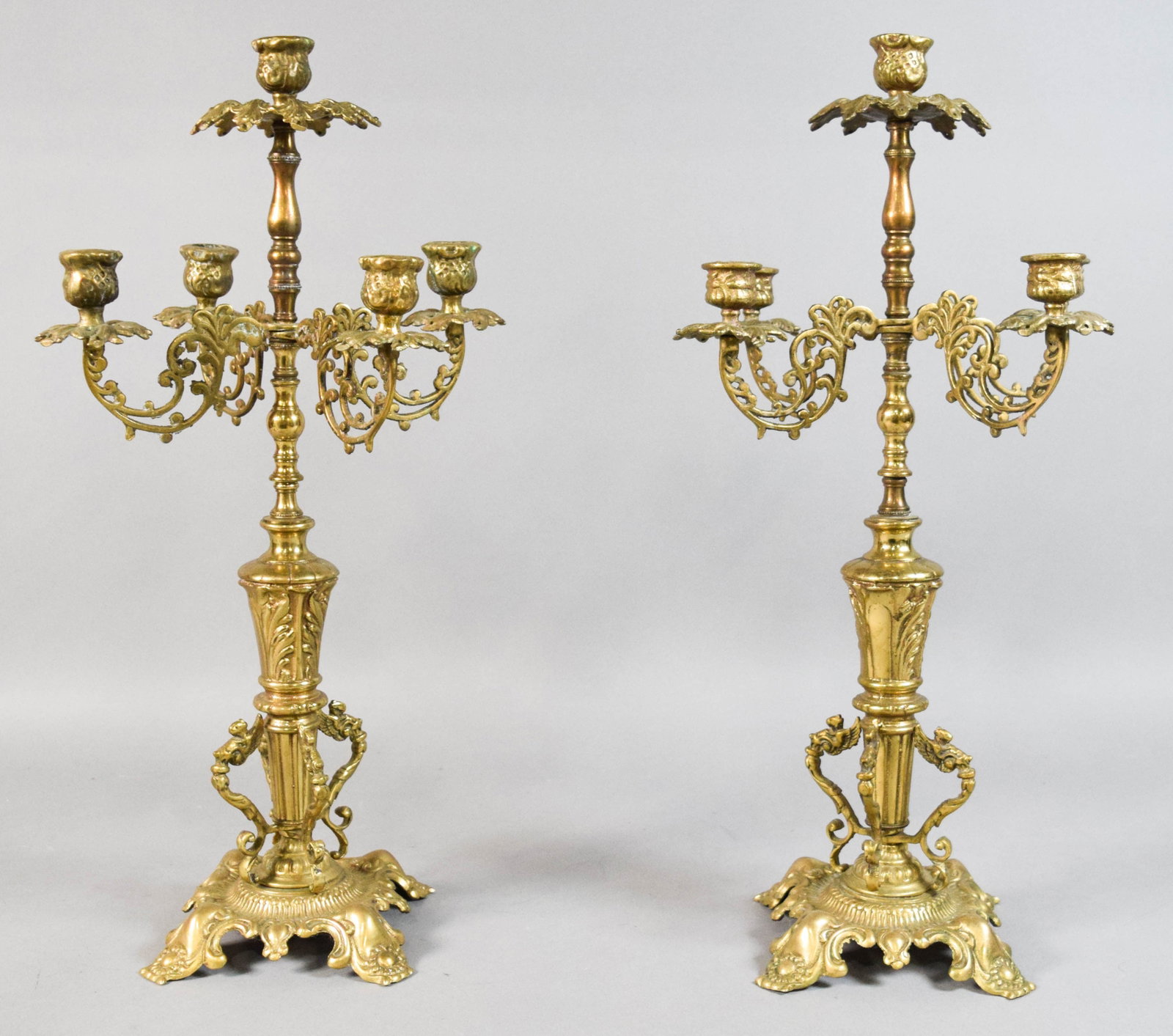 Pair of Brass Rococo Revival Style Candelabra: Pair of Rococo Revival style cast brass five-light candelabra. Decorated with acanthus leaves and chimera-like figures. Late 19th to early 20th century. 22" H x 6 1/2" diameter.