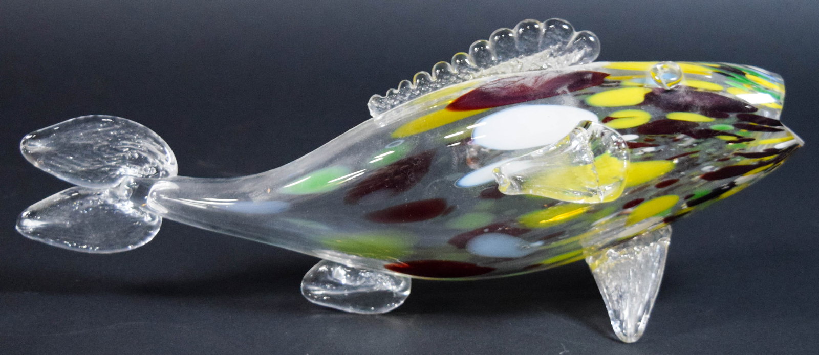 Large Hand-Blown Art Glass Fish Figurine: Large hand-blown art glass fish paperweight. Clear body with internal confetti inclusions. Appears unsigned. 5" H x 3 1/2" W x 18" L.
