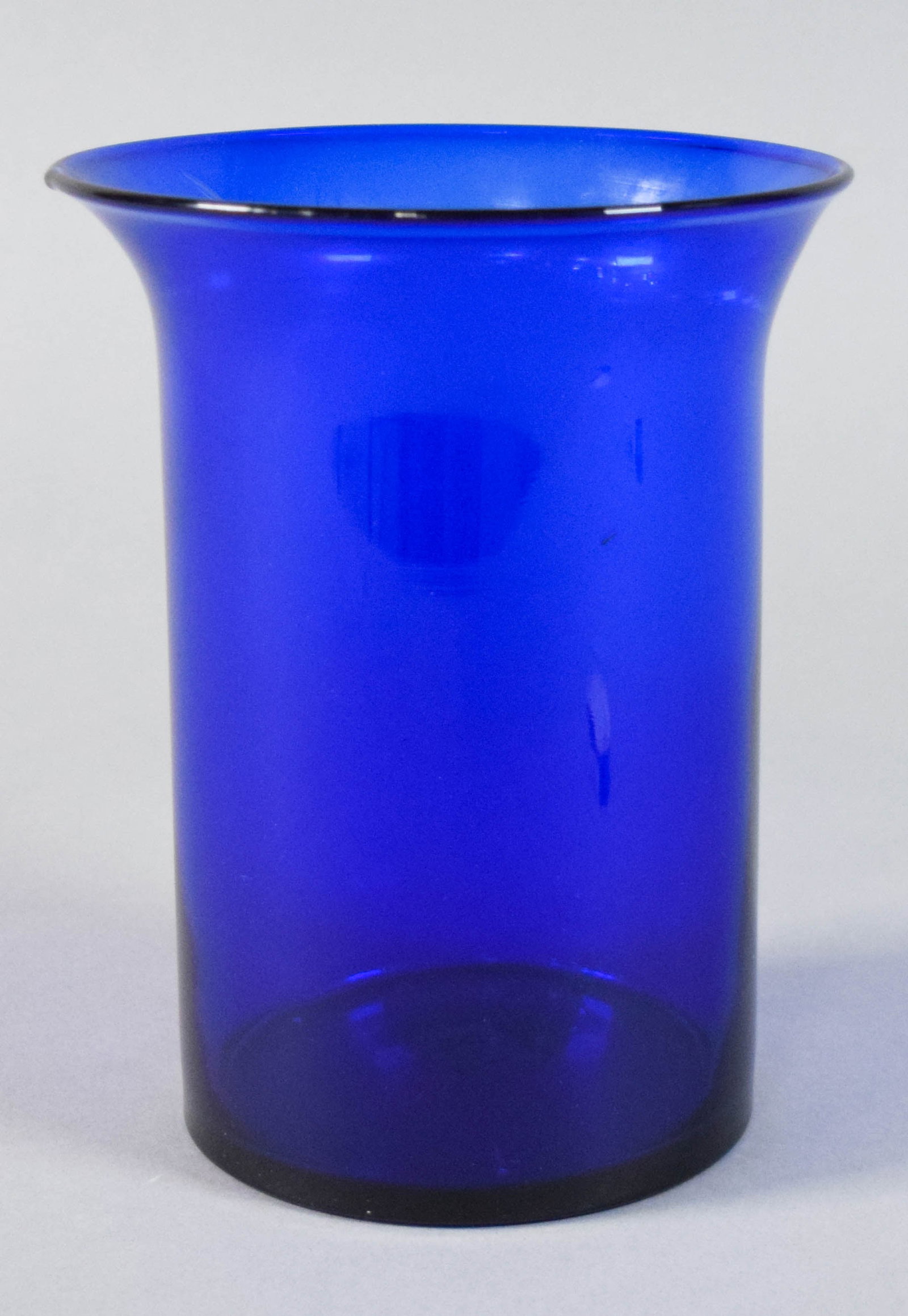 MCM Cobalt Blue Hand-Blown Glass Vase with Flared Rim: Mid-Century Modern hand-blown cobalt blue art glass vase. Underside of the base with a ground and polished pontil scar. Appears unsigned. 7 1/2" H x 5 1/2" diameter at the rim.