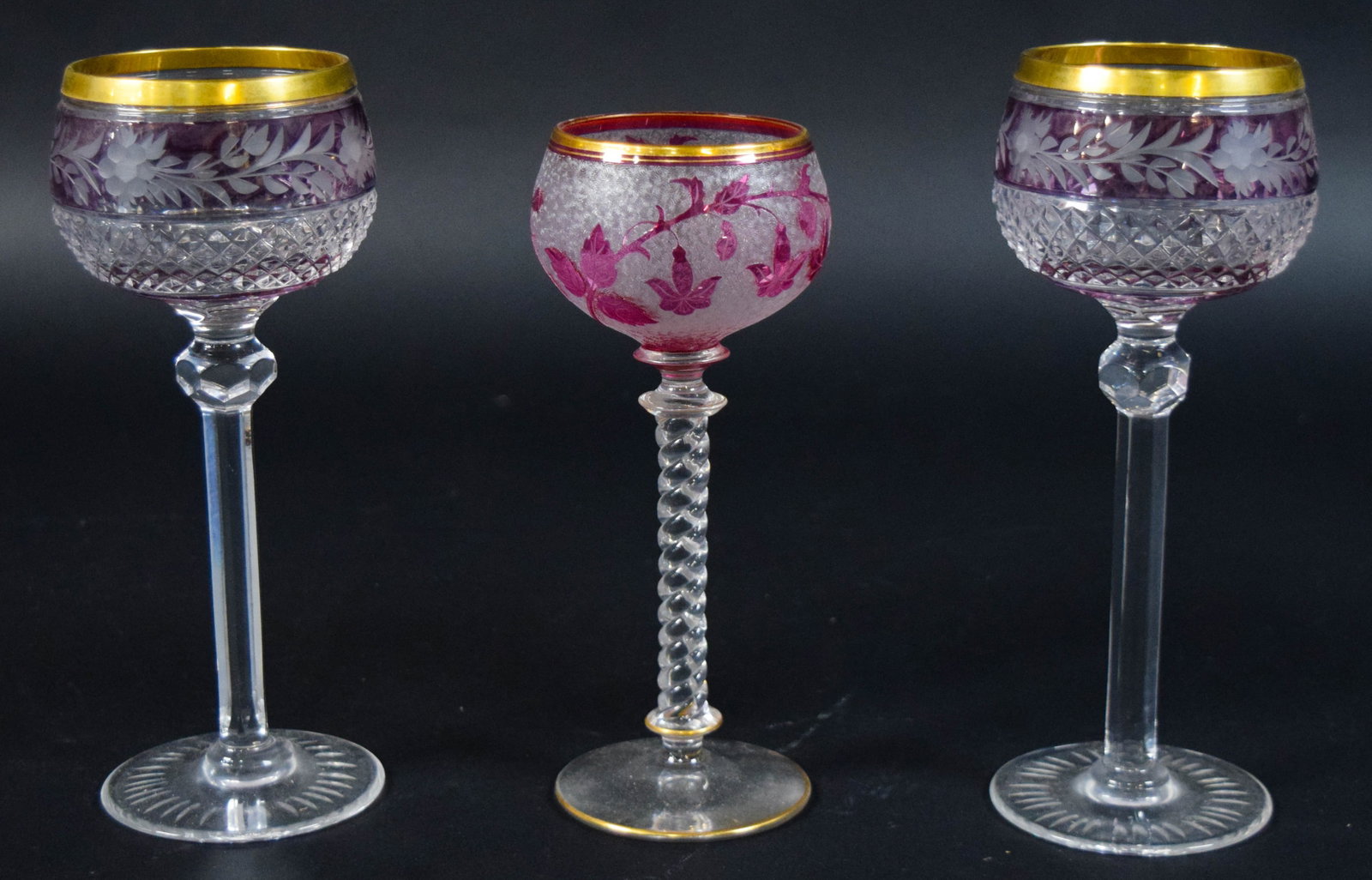 Group of 3 European Cut Glass Goblets: Group of three decorative cut glass goblets of European design. Includes a matching pair of amethyst goblets and a single cranberry glass goblet. Largest 8 1/2" H x 4 1/8" base diameter.