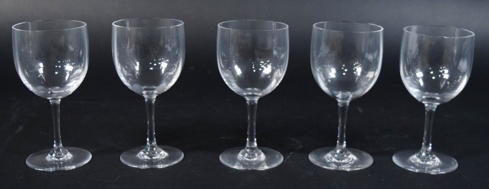 Set of 5 Baccarat Perfection Crystal Wine Glasses: Set of five Baccarat lead crystal wine glasses in the Perfection pattern. Plain, rounded bowl with a flat circular foot. Each glass signed on the underside of the base and on the upper side of the foo