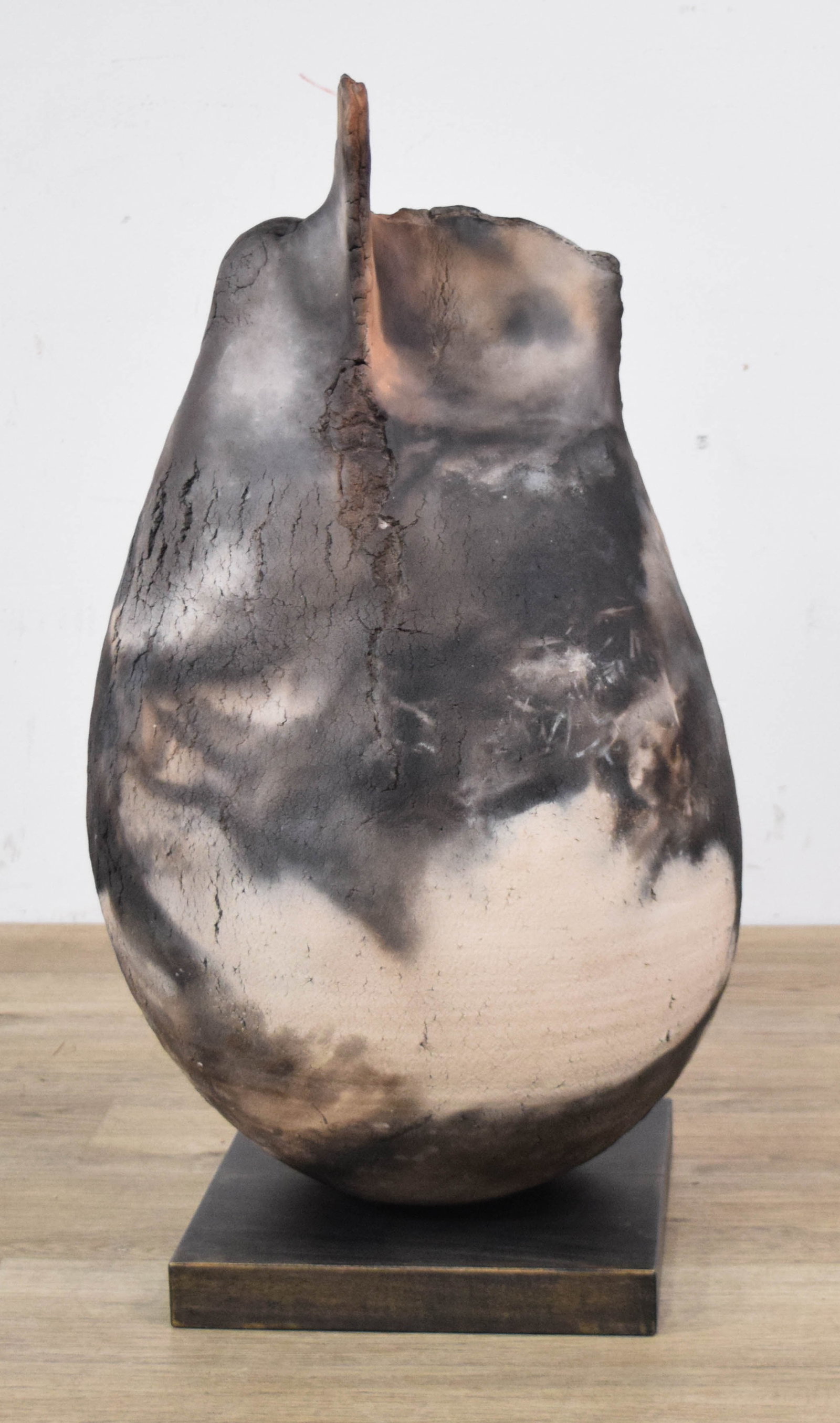 Large Pit-Fired Teardrop Ceramic Sculpture: Large pit-fired ceramic teardrop sculpture. Constructed from a buff-colored clay body with a coarse, sandy surface texture. The piece exhibits a pit-fired or smoke-fired finish with variegated carbon-