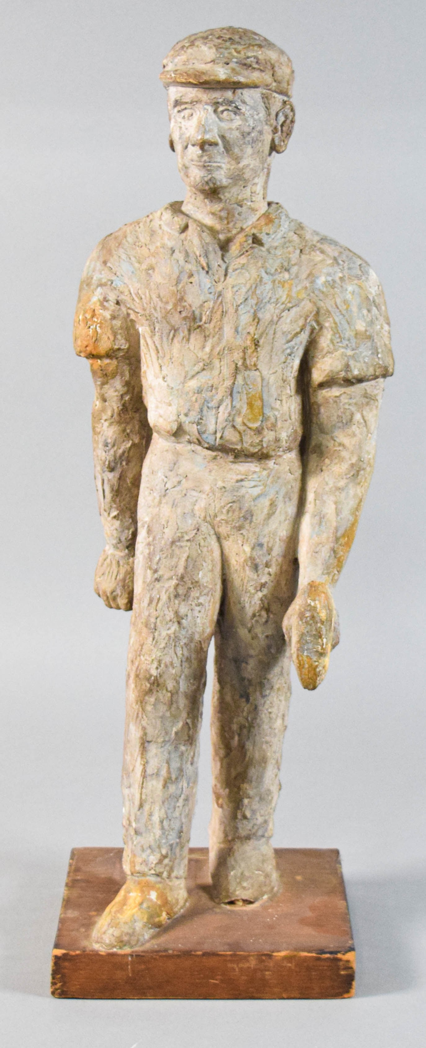 American Folk Art Sculpture of a Laborer: Large American folk art sculpture of a laborer. The piece is constructed from a heavily textured and painted composition or plaster material, presenting a rough-hewn surface finish. The sculpture is m