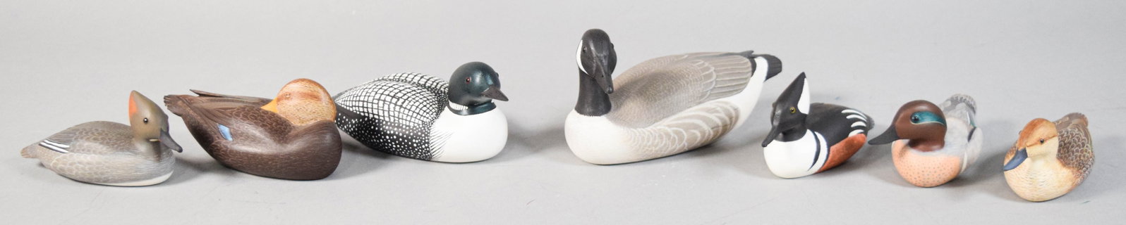 Group of 7 Rob Lasher Miniature Duck Decoys: Group of seven miniature wooden waterfowl decoys hand carved and painted by artist Rob Lasher of St. Albans, Vermont. Each decoy identified on the underside: Canada Goose, Loon, Black Duck, Hooded Mer