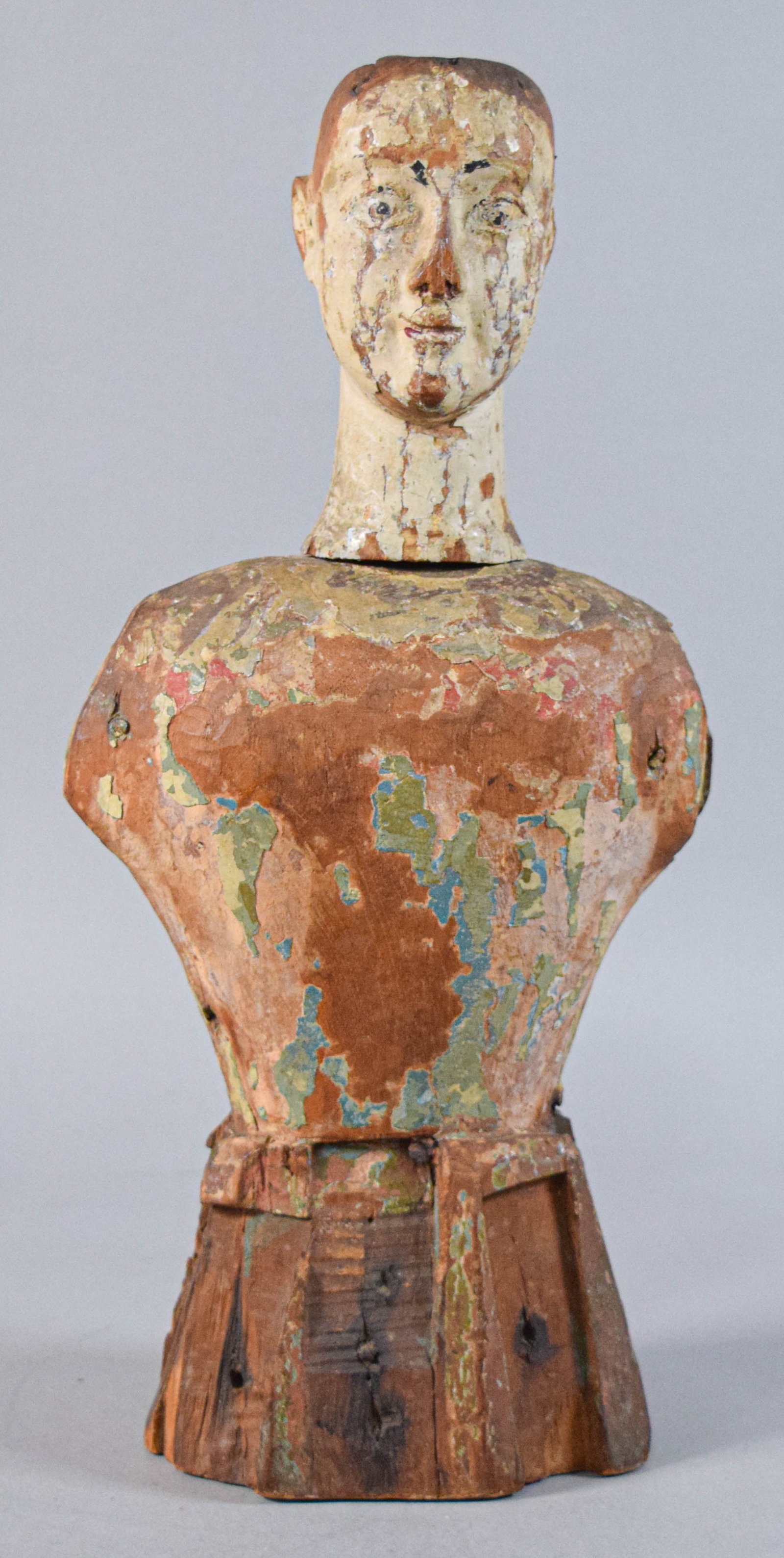 Antique Carved Wood Santos Mannequin: Carved wooden Santos figure with remnants of polychrome paint and gesso layers throughout. Large rectangular mortises at the shoulders with interior wooden pins, missing arms. 16" H x 7 1/2" W x 4" D.