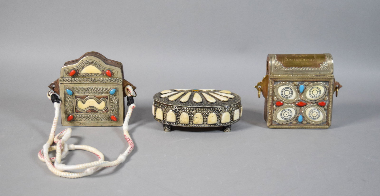 Group of 3 Mixed Metal and Inlaid Moroccan Prayer Boxes: Group of three Moroccan mixed metal and inlaid prayer boxes. Decorated with coral and turquoise cabochons. Oval box with interior leather lining. Largest 5 1/2" H x 6" W x 2 1/2" D.
