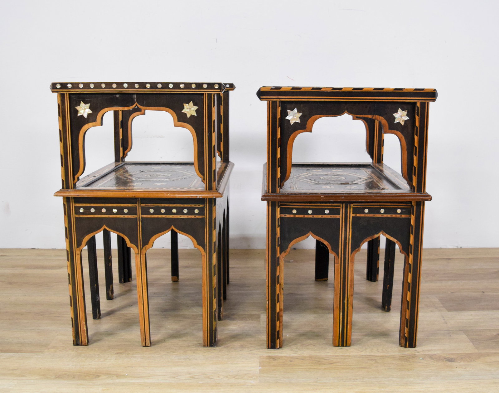 Pair of Moroccan Mother of Pearl Inlaid Benches with Stone Tops: Pair of Moroccan mother-of-pearl inlaid benches with removable stone tops. One bench with three arched cutouts on the aprons, other bench with two arched cutouts. With tops 30 1/2" H x 24" W x 18" D.