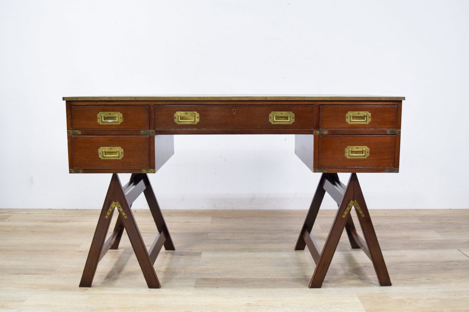 Campaign Desk with Leather Top: Campaign trestle desk with five drawers and inset leather top. Leather surface decorated with Greek key border. Drawer fronts and sides with brass corner strapping and a brass-protected edge around th