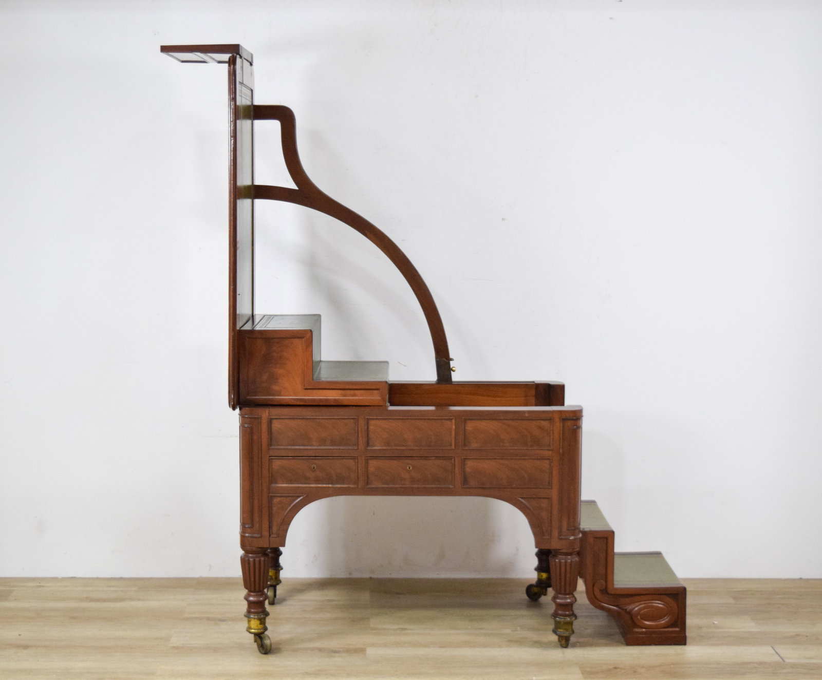 Mahogany Metamorphic Library Table and Steps: Regency style mahogany metamorphic library table transforming into a six-step library ladder. Rectangular tabletop and stair treads inset with green leather panels decorated with gilded Greek key bord