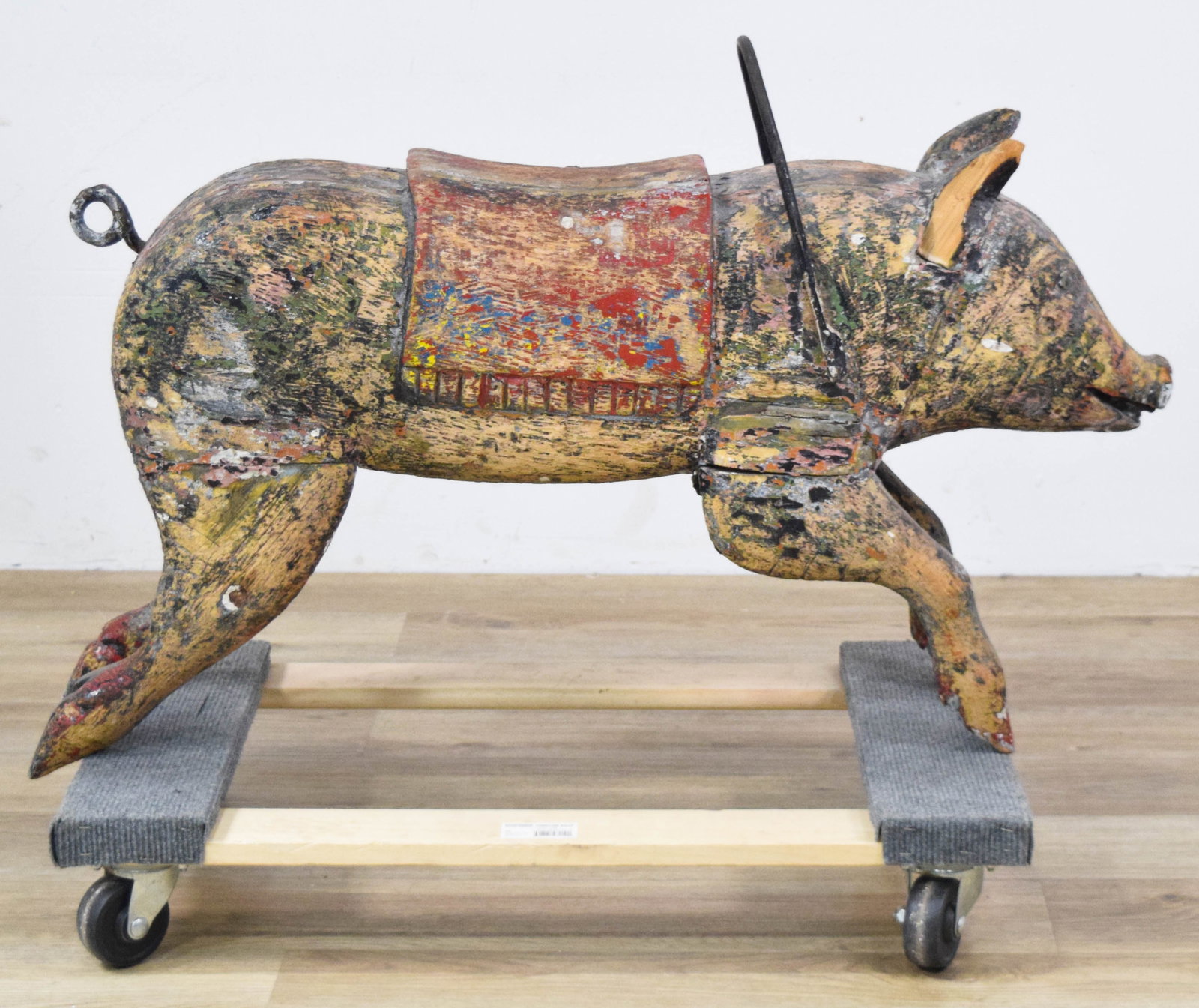 American Carved Wood Carousel Pig Figure: American folk art carousel pig figure, late 19th to early 20th century. Wood carved figure with a curled metal tail and iron U-shaped handle mounted behind the head. 24" H x 35" L x 8" W.