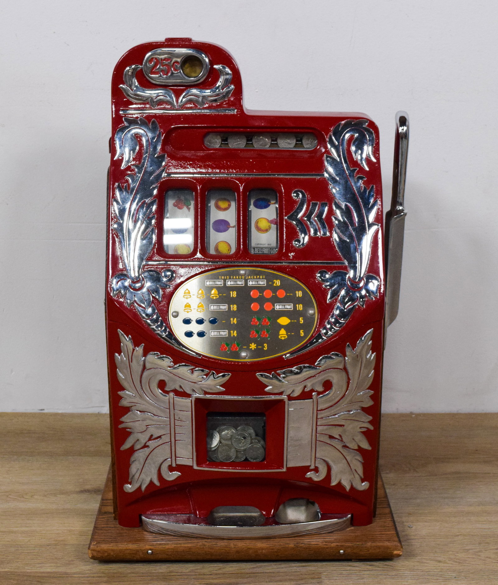Mills Novelty Co. 25-Cent Castle Front Slot Machine: Mills Novelty Co. 25-cent castle front slot machine. Three mechanical reels display classic fruit and bell symbols, with labels bearing the Copyright 1910 Bell-Fruit-Gum and Mills Novelty Co. Chicago 
