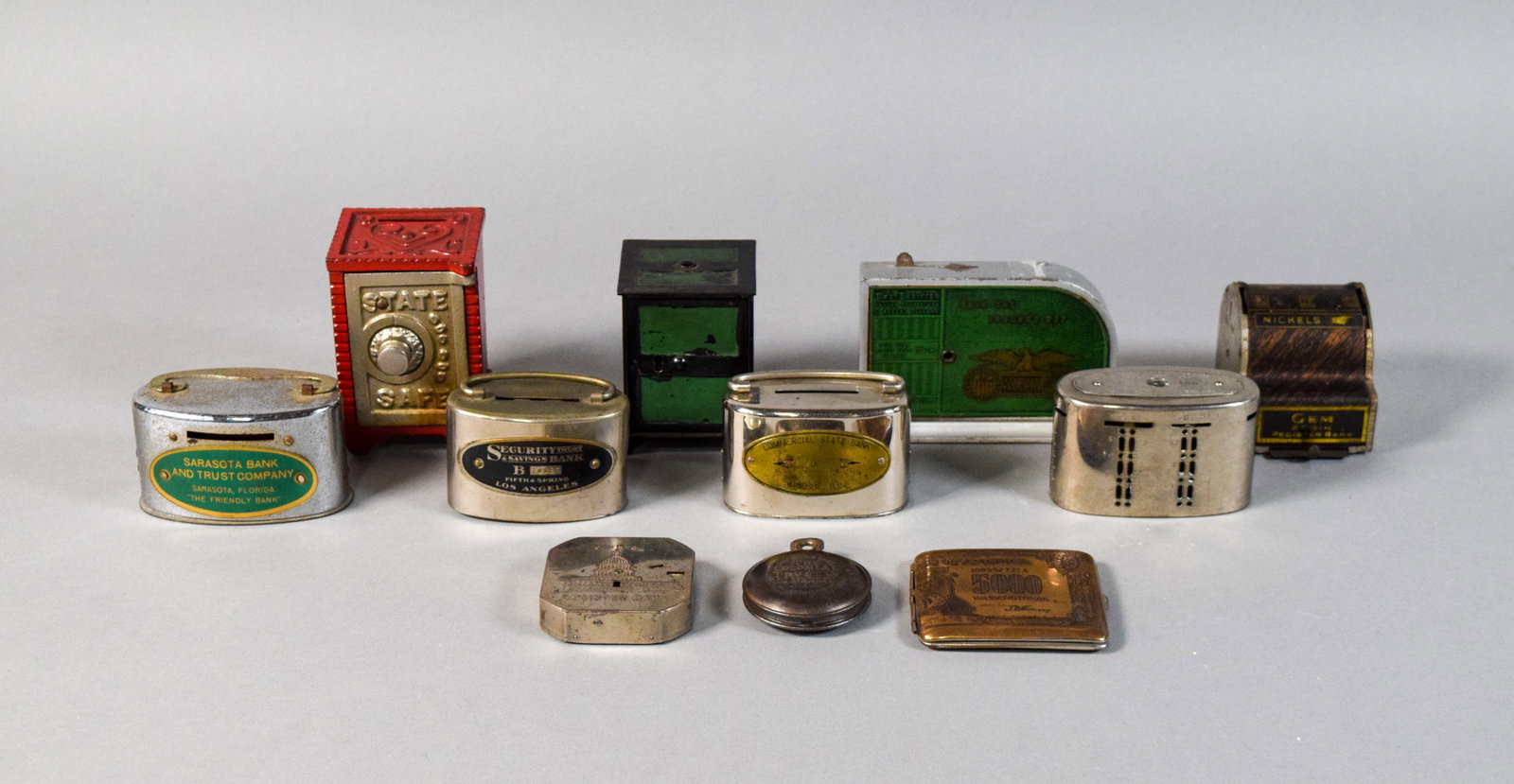 Group of 11 Vintage and Antique Coin Banks: Group of 11 vintage and antique metal toy and promotional coin banks. Includes two cast iron safe banks, two register banks, four plated metal promotional banks, two pocket-sized banks, and a metal ca