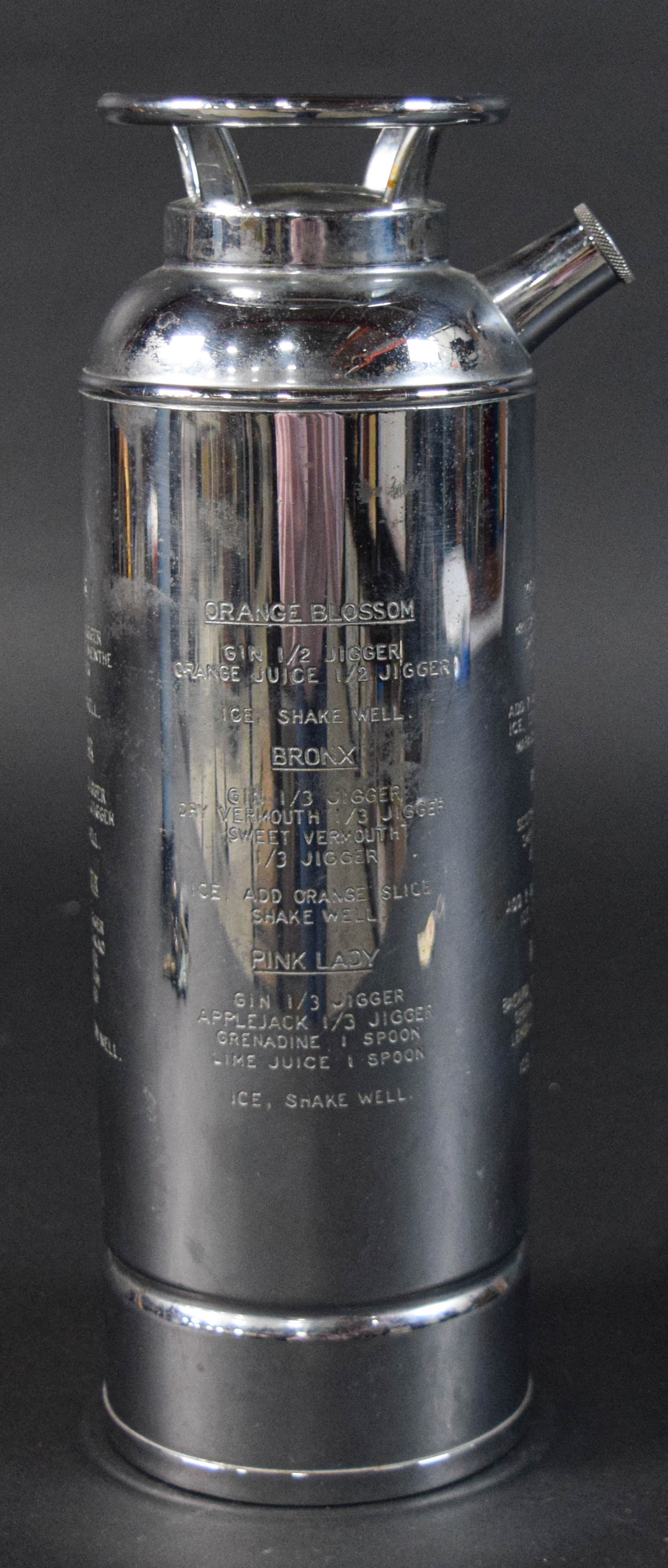 Art Deco Style Chrome-Plated Fire Extinguisher Cocktail Shaker: Art Deco style chrome-plated fire extinguisher cocktail shaker. Body engraved with cocktail recipes. Appears unsigned. 11 1/2" H x 4 3/4" diameter.